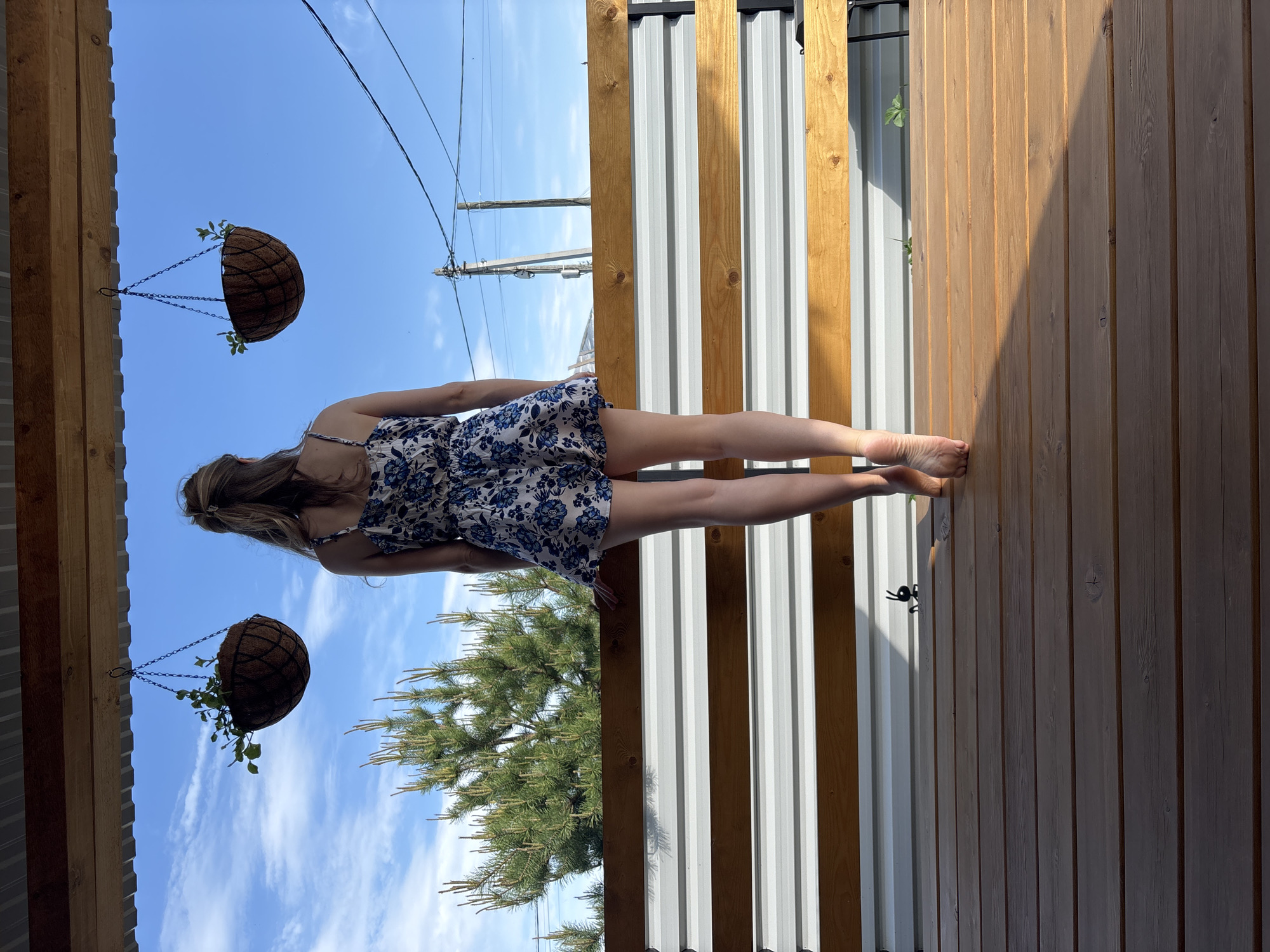 Woman poses for outdoor photo session on wooden deck