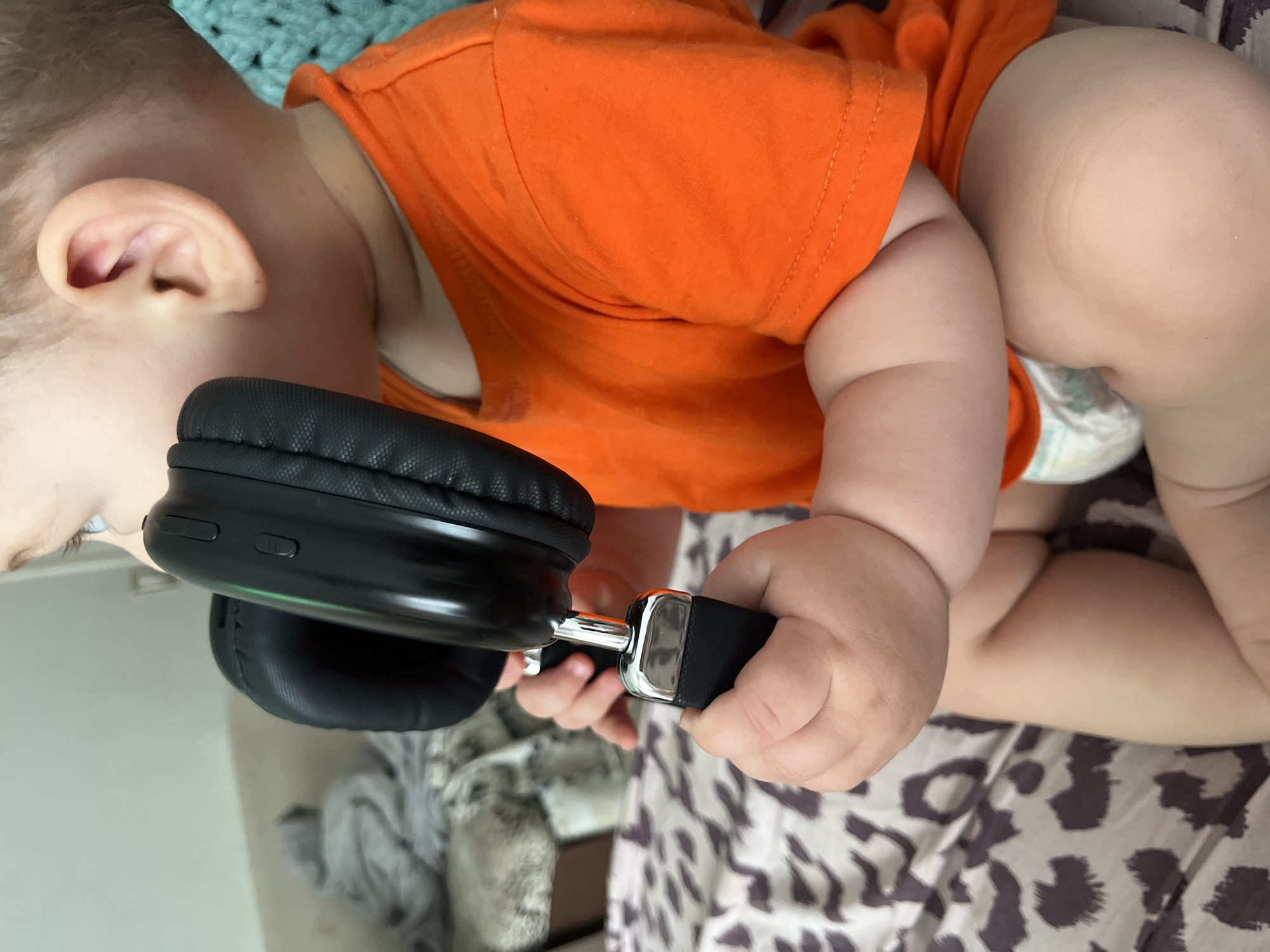 Toddler explores headphones during a lazy morning at home