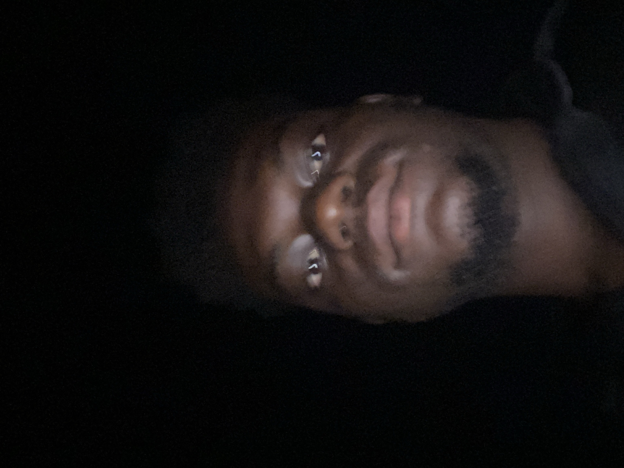 Low-light portrait of bearded man captured in darkness
