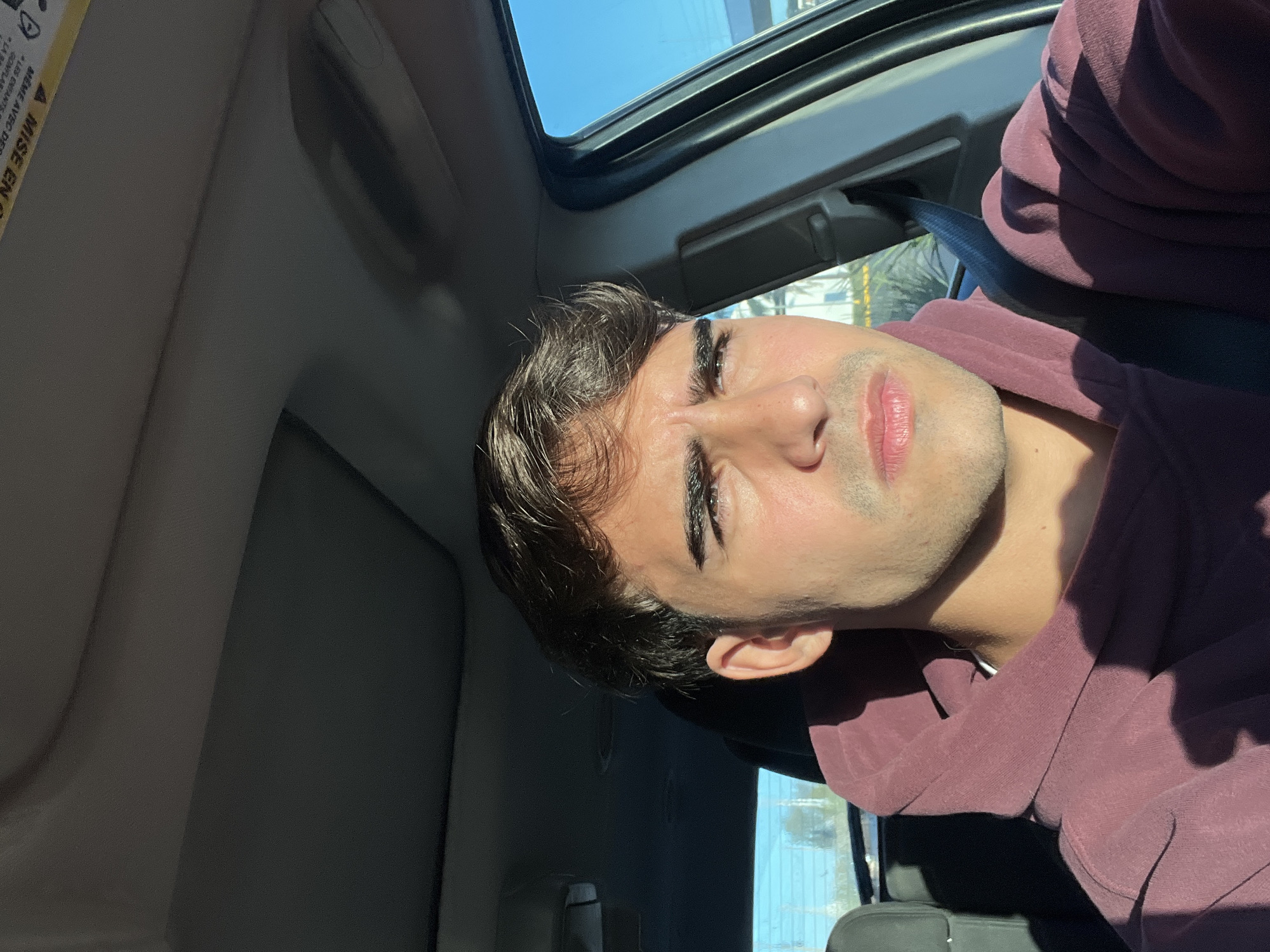 Young man photographed in car with sunroof in Sarandí