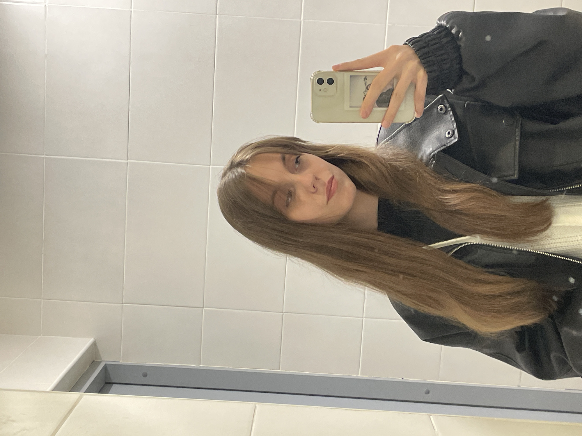 Woman takes mirror selfie in Ufa restroom