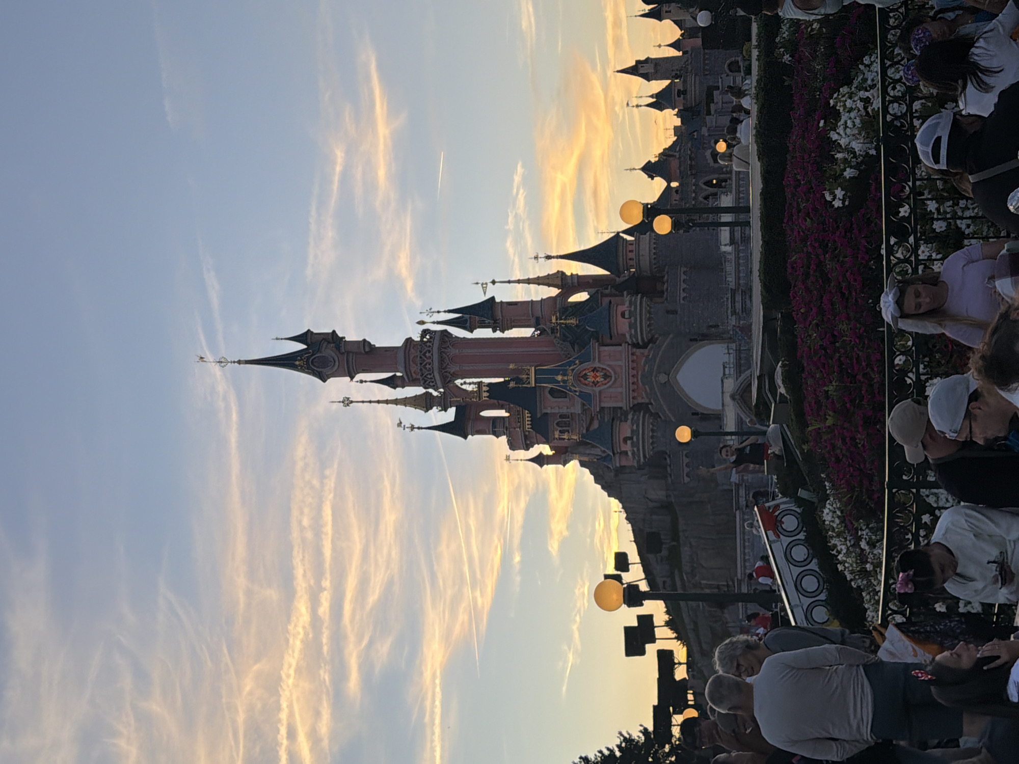 Sleeping Beauty Castle glows under a warm dusk sky