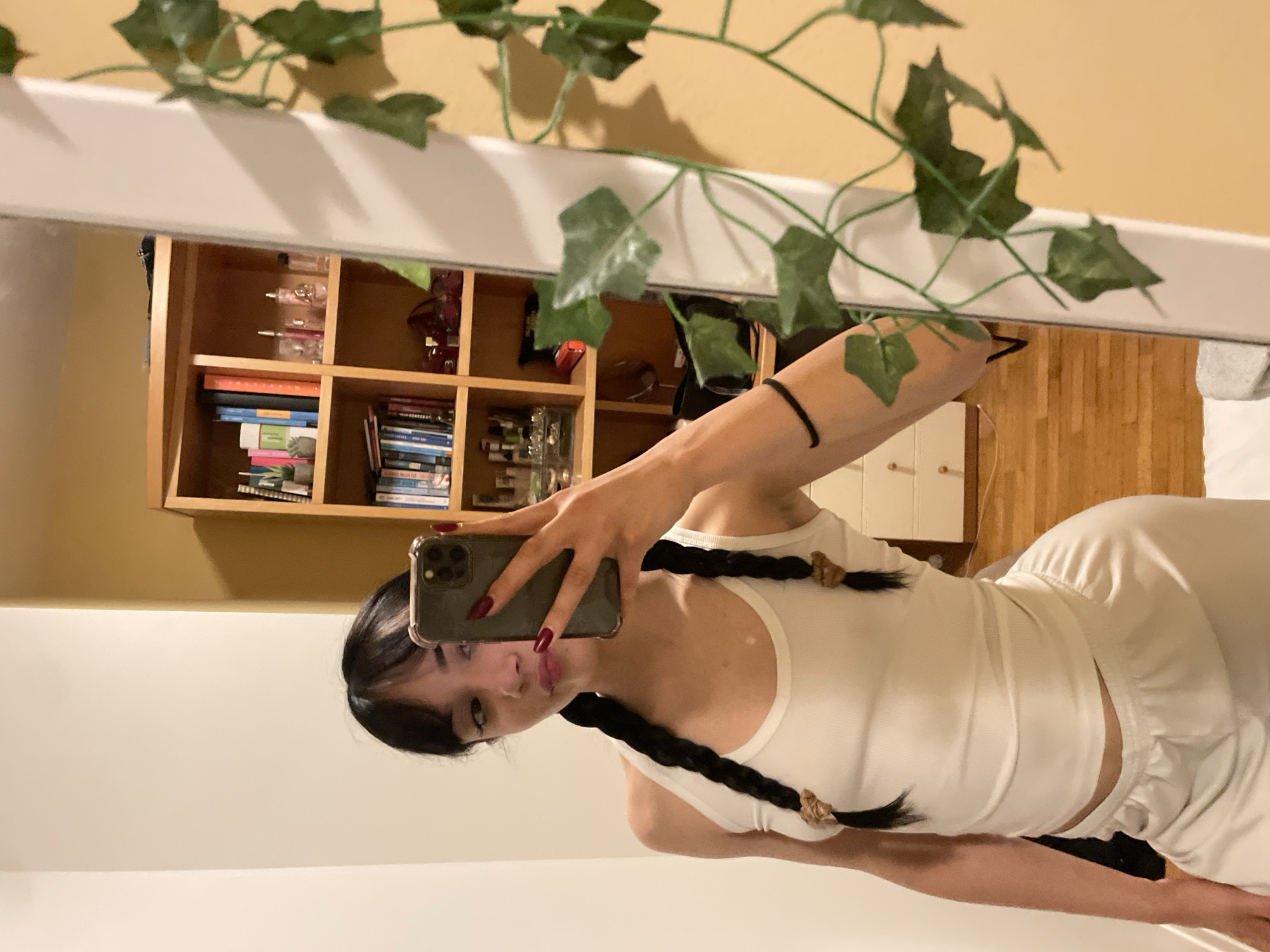 Woman takes mirror selfie in bedroom in Cassano Magnago