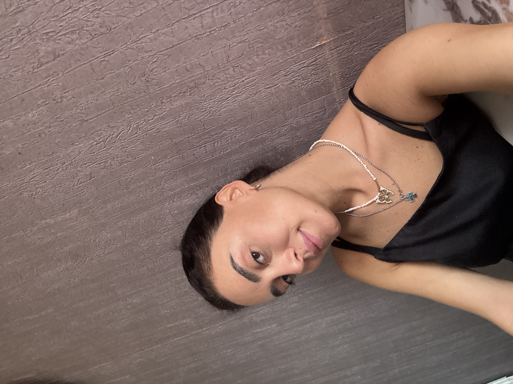 Layered necklaces and a relaxed pose, indoors in Tbilisi