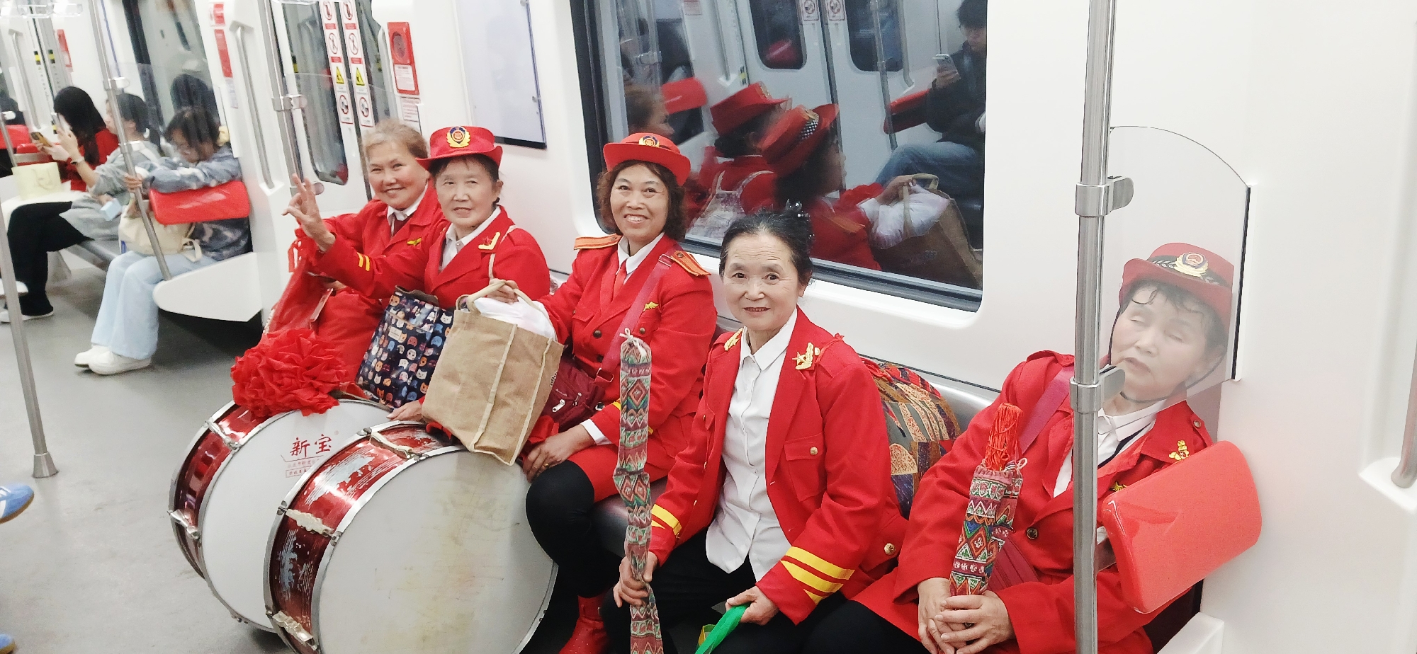 Uniformed women with drums ride Chongqing subway train