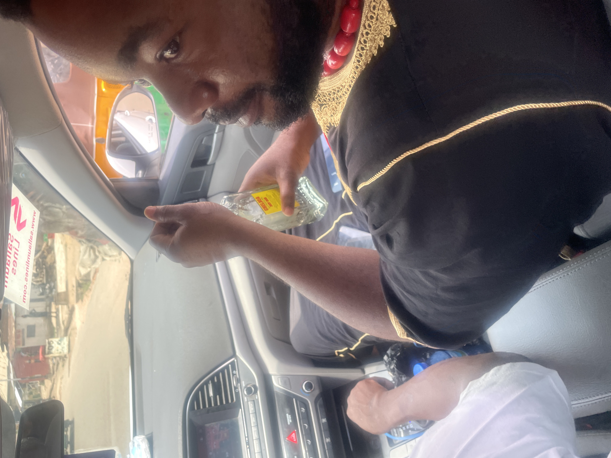 Man in traditional robes pours yellow liquid in Jos