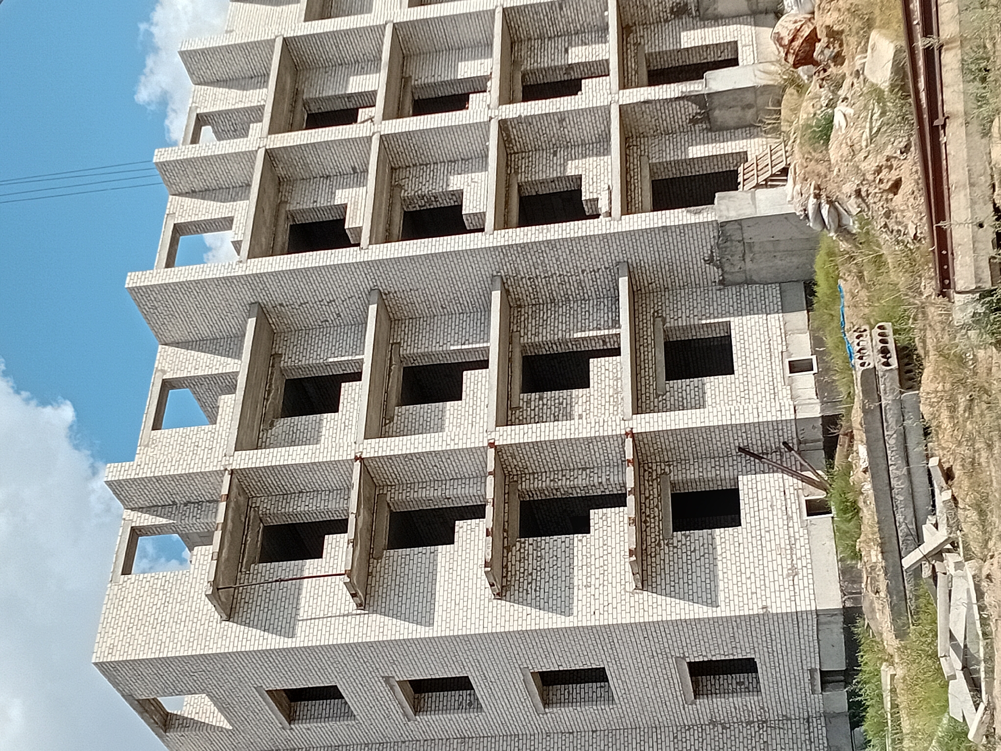 White brick building mid-construction, facade and floors still unfinished
