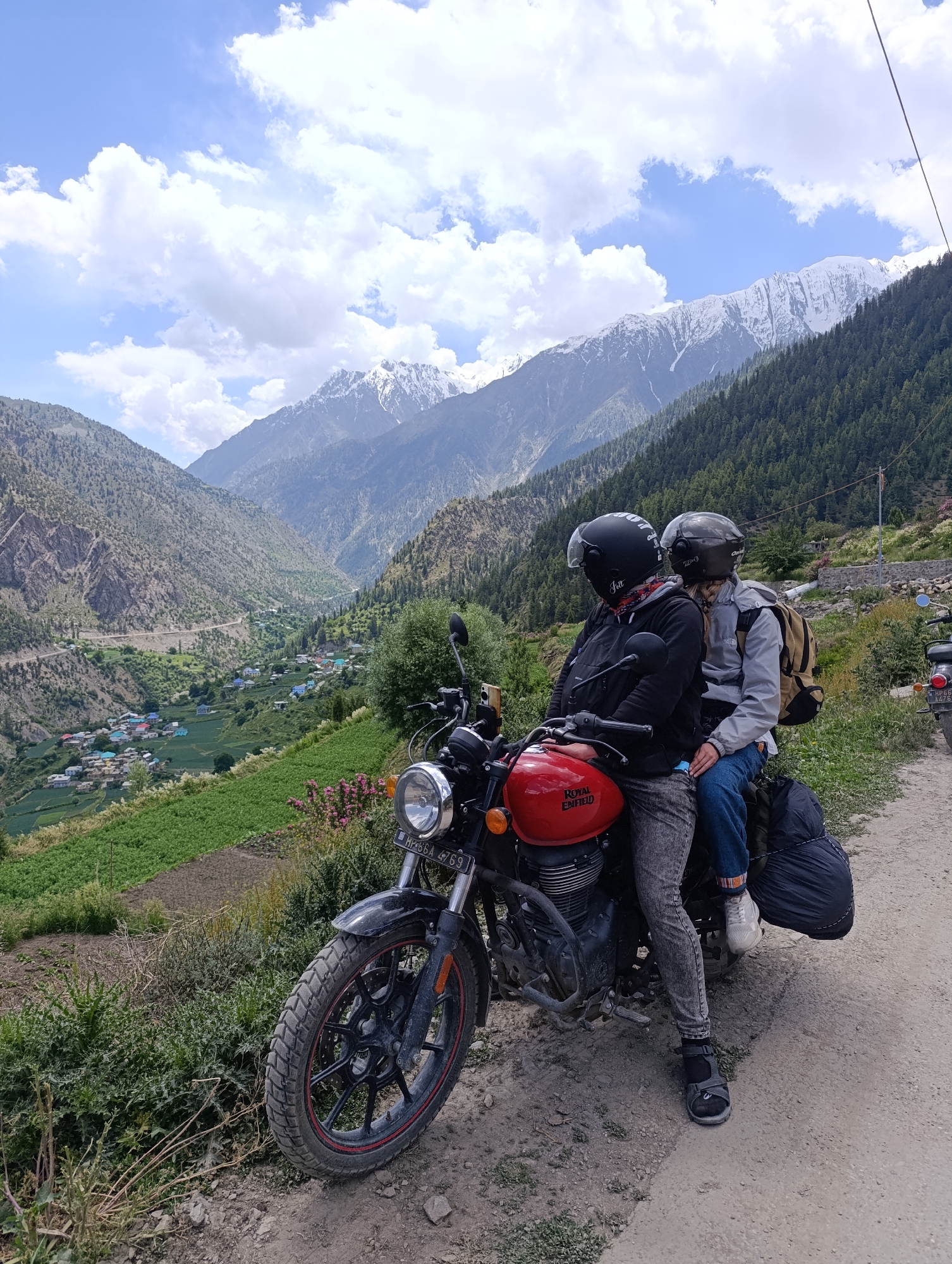 Red Royal Enfield with two riders in Kishori, India
