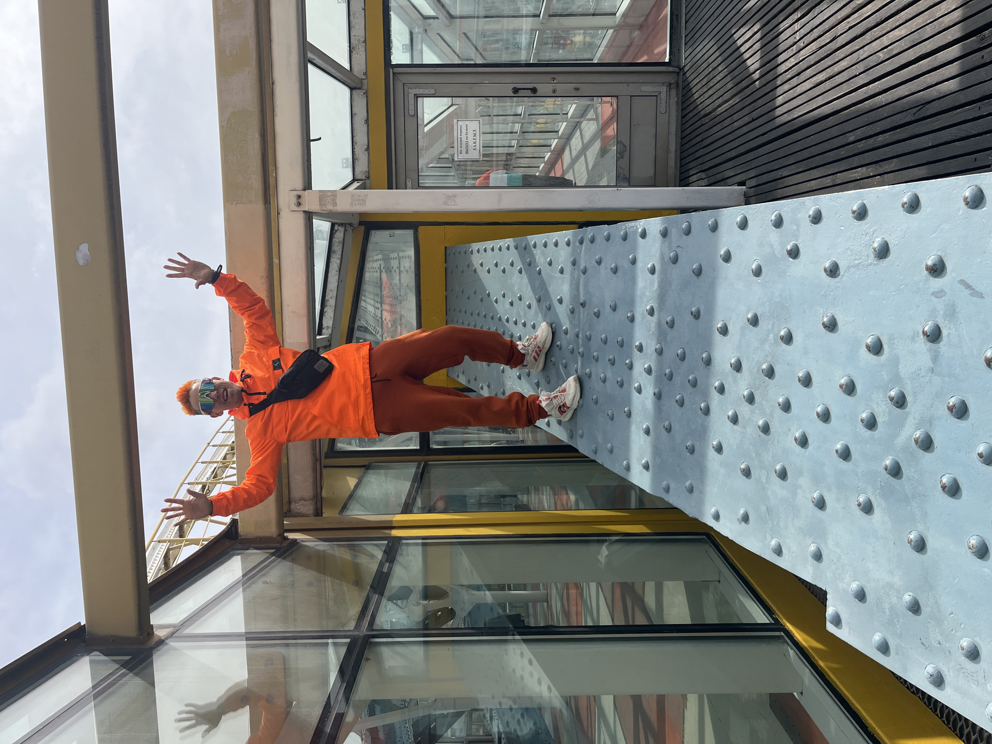 Colorful-dressed person poses on Moscow walkway near GUM store