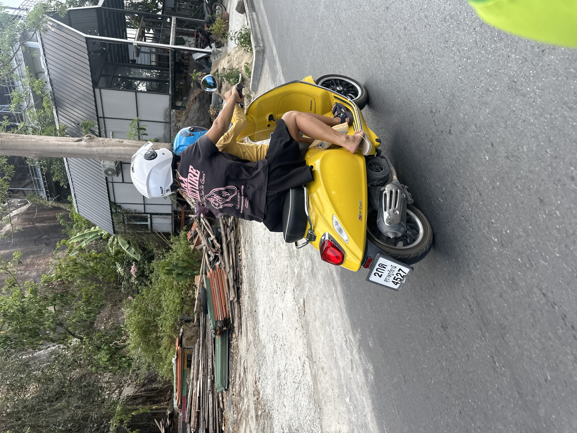 Two riders spotted on yellow Vespa in Thai coastal town