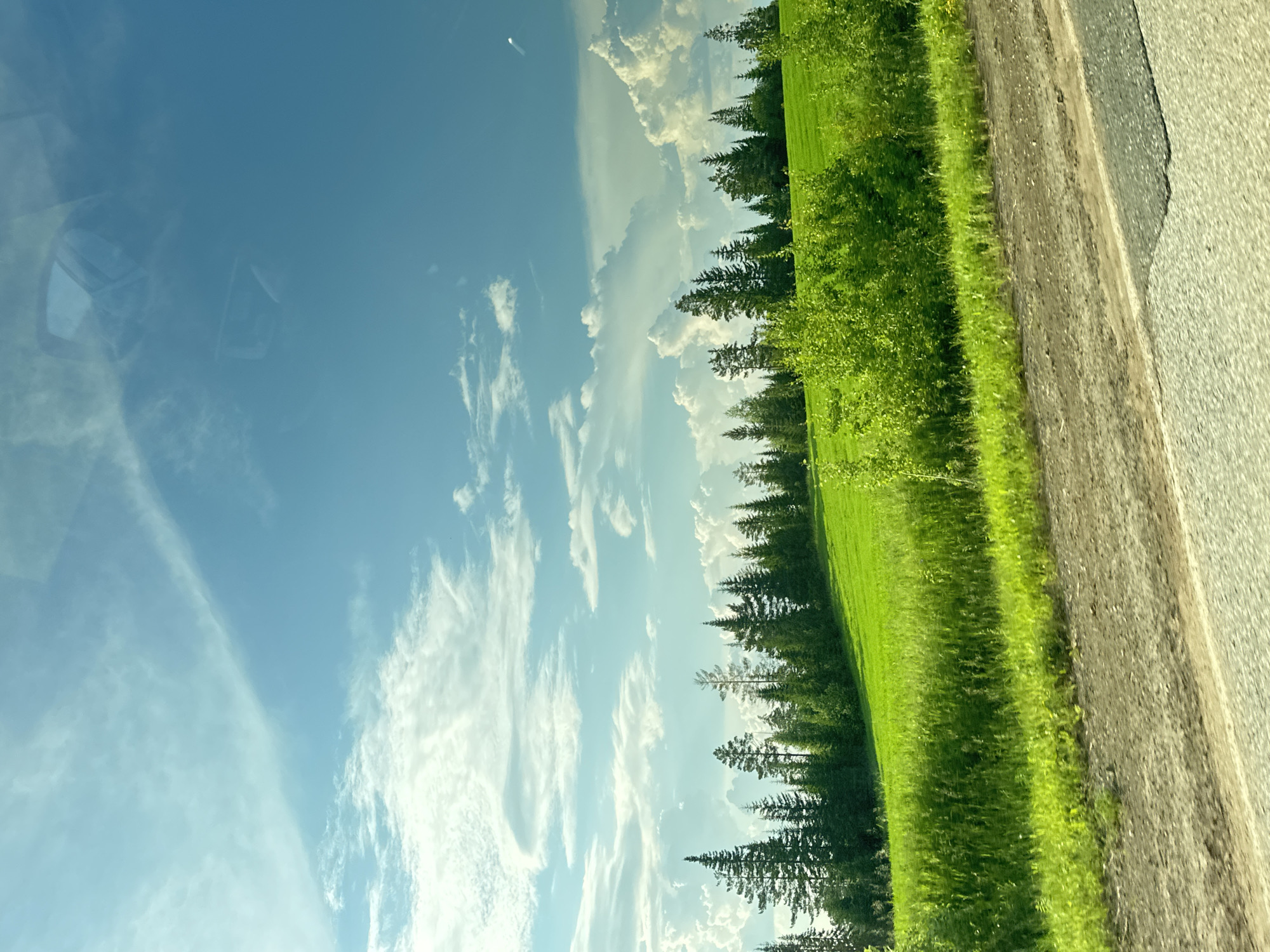 Rural road through Buranovo countryside under partly cloudy skies