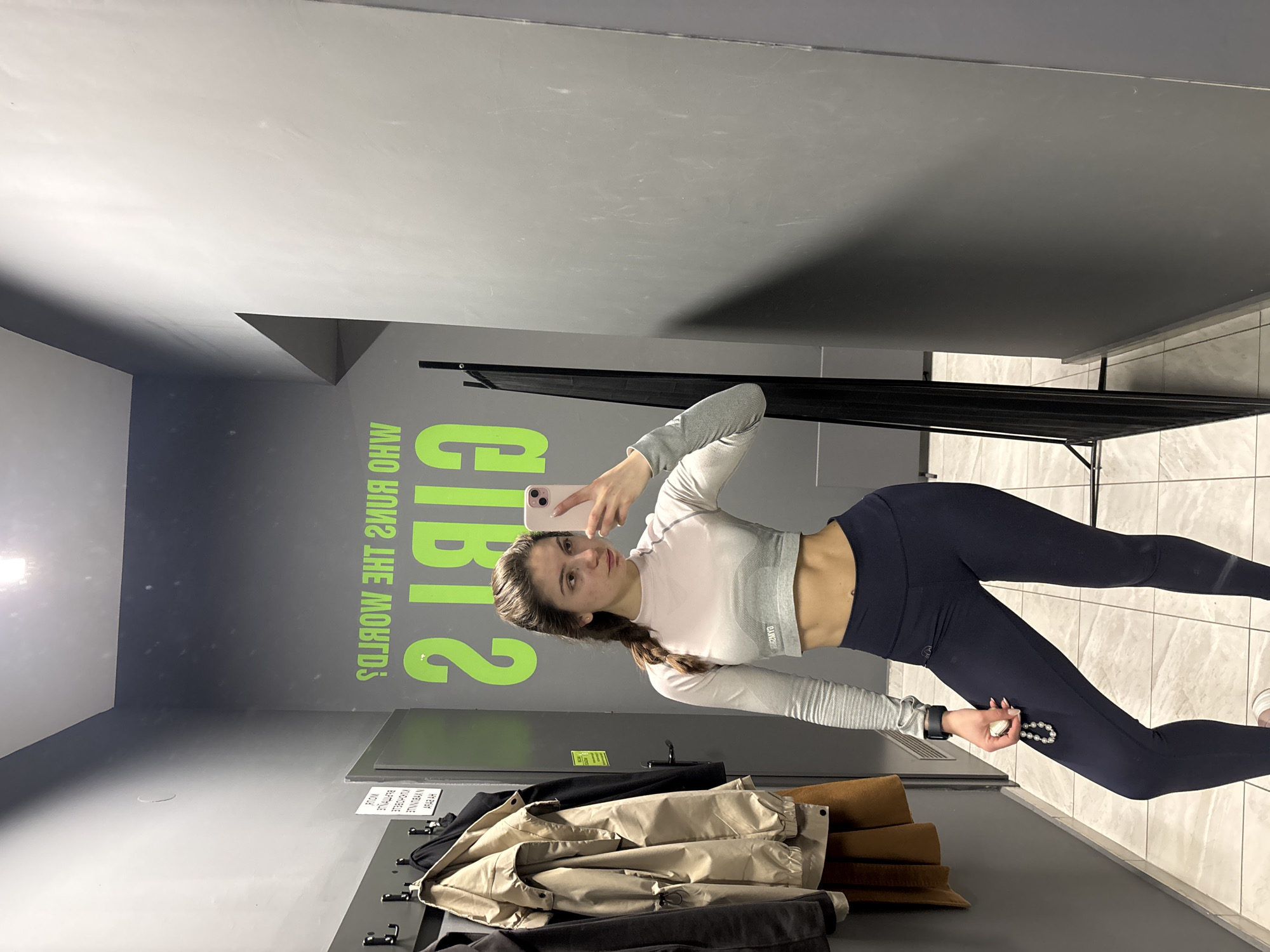Woman takes gym selfie in motivational locker room