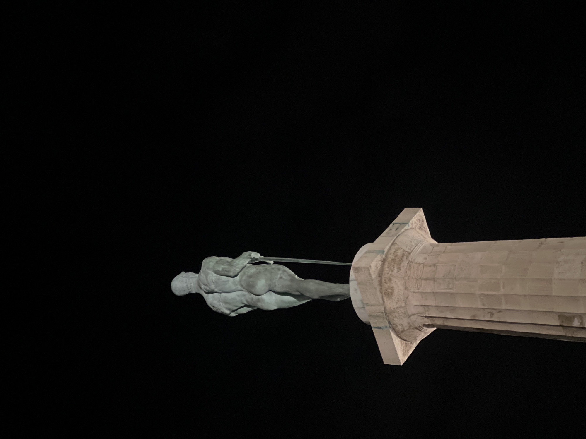 Person holds Patrick Star plush near sword statue in Belgrade