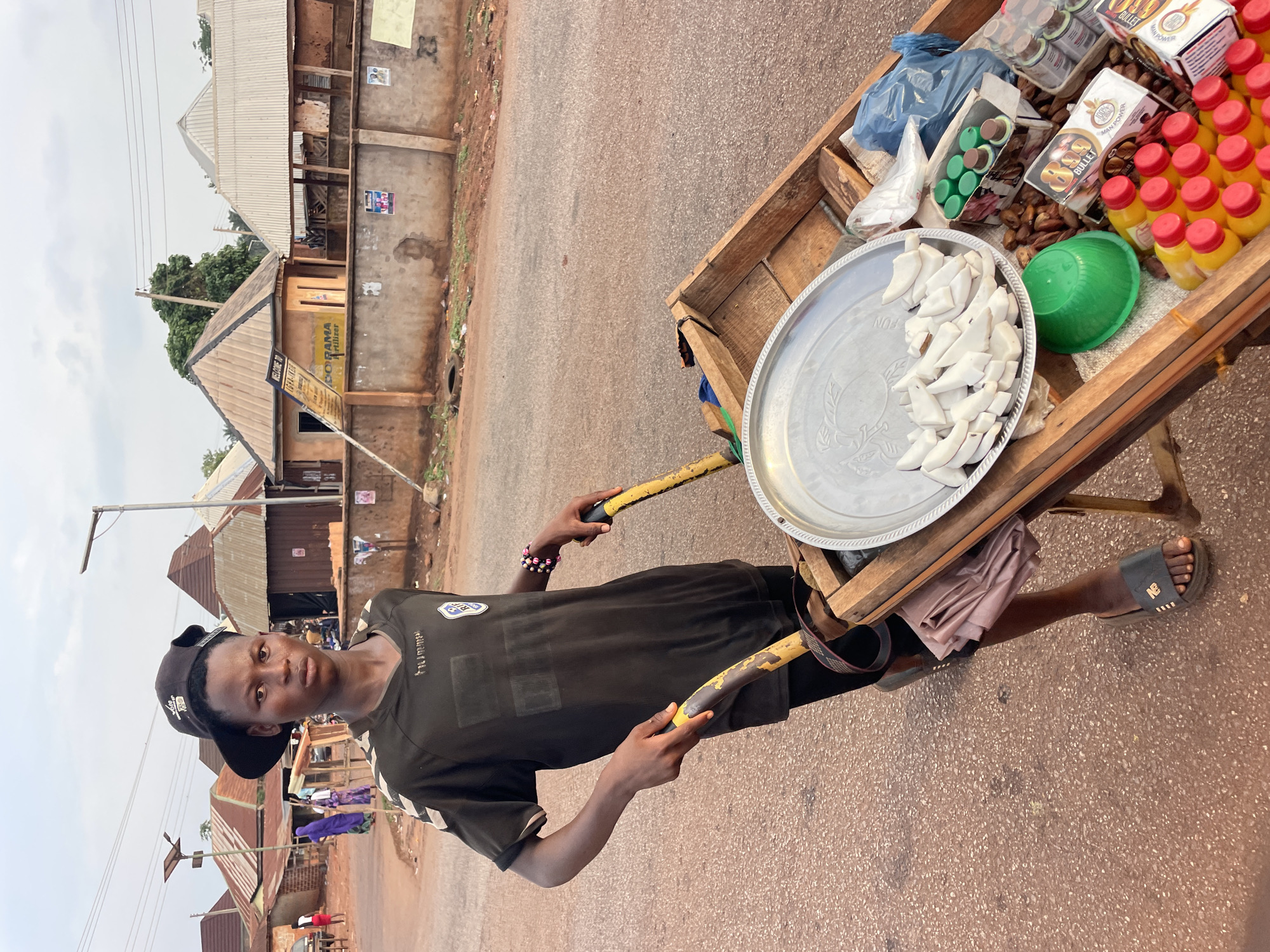 Man in black clothing stands on red road in Apunu