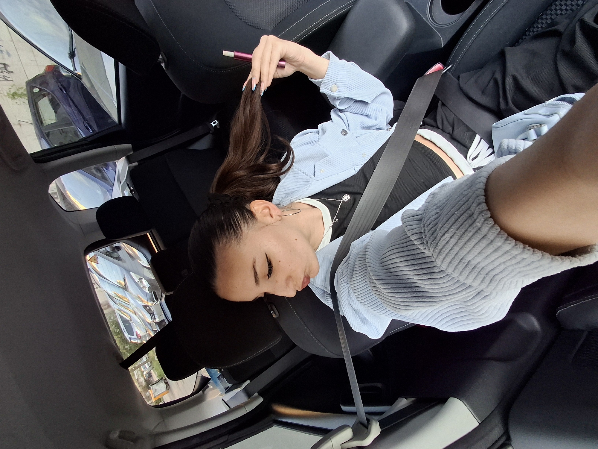 Woman rests in car passenger seat, Sofia