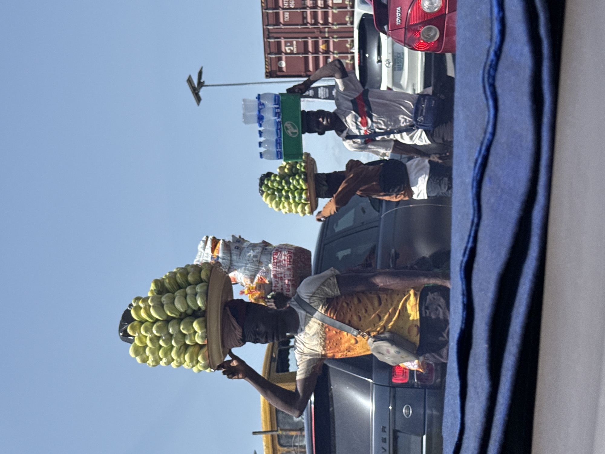 Street vendors sell fruit between traffic lanes in Ilado
