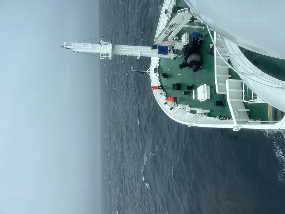 Ship navigates rough waters with crew on bridge