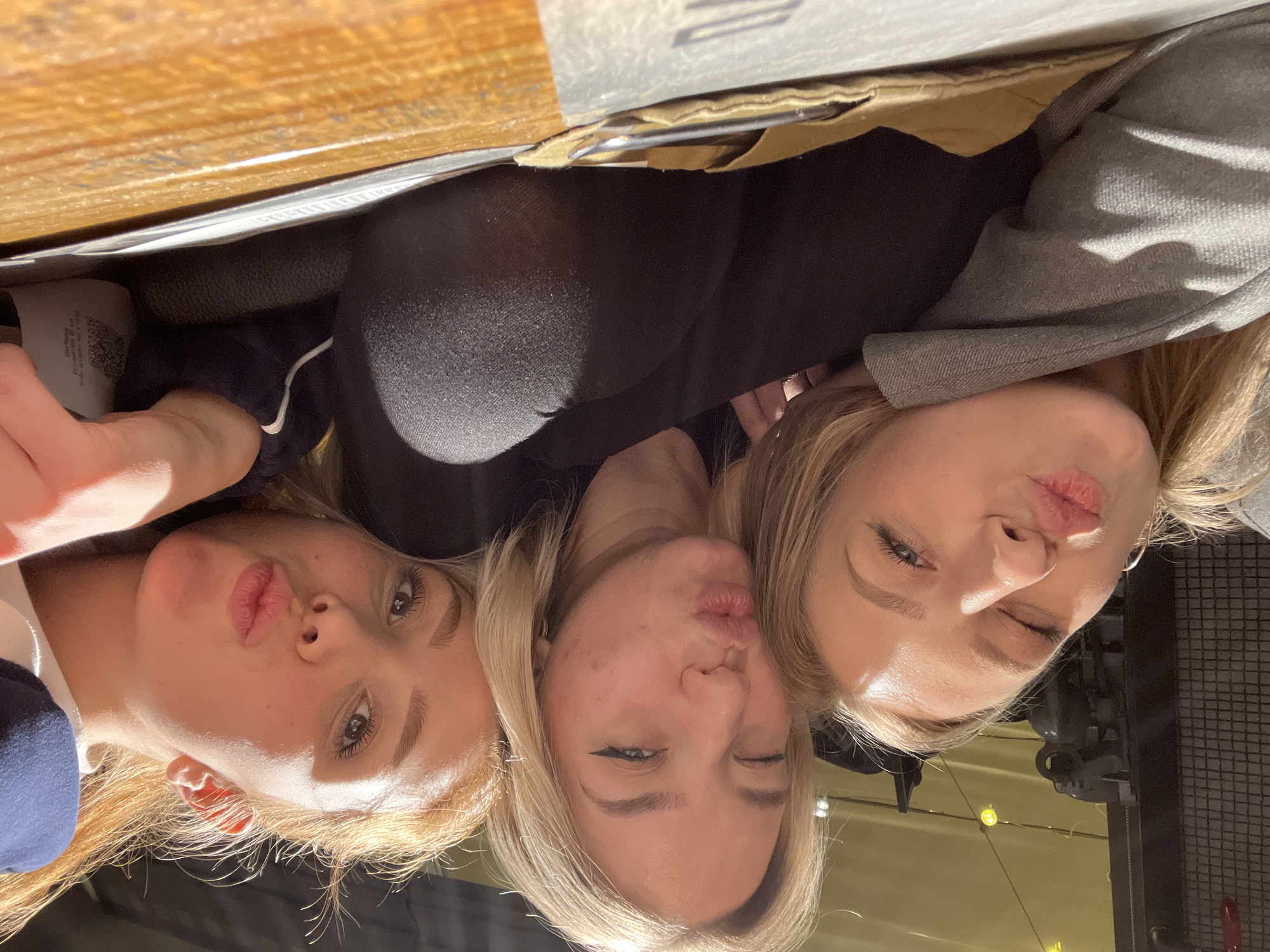 Three women dine and pose playfully at Krasnoyarsk restaurant