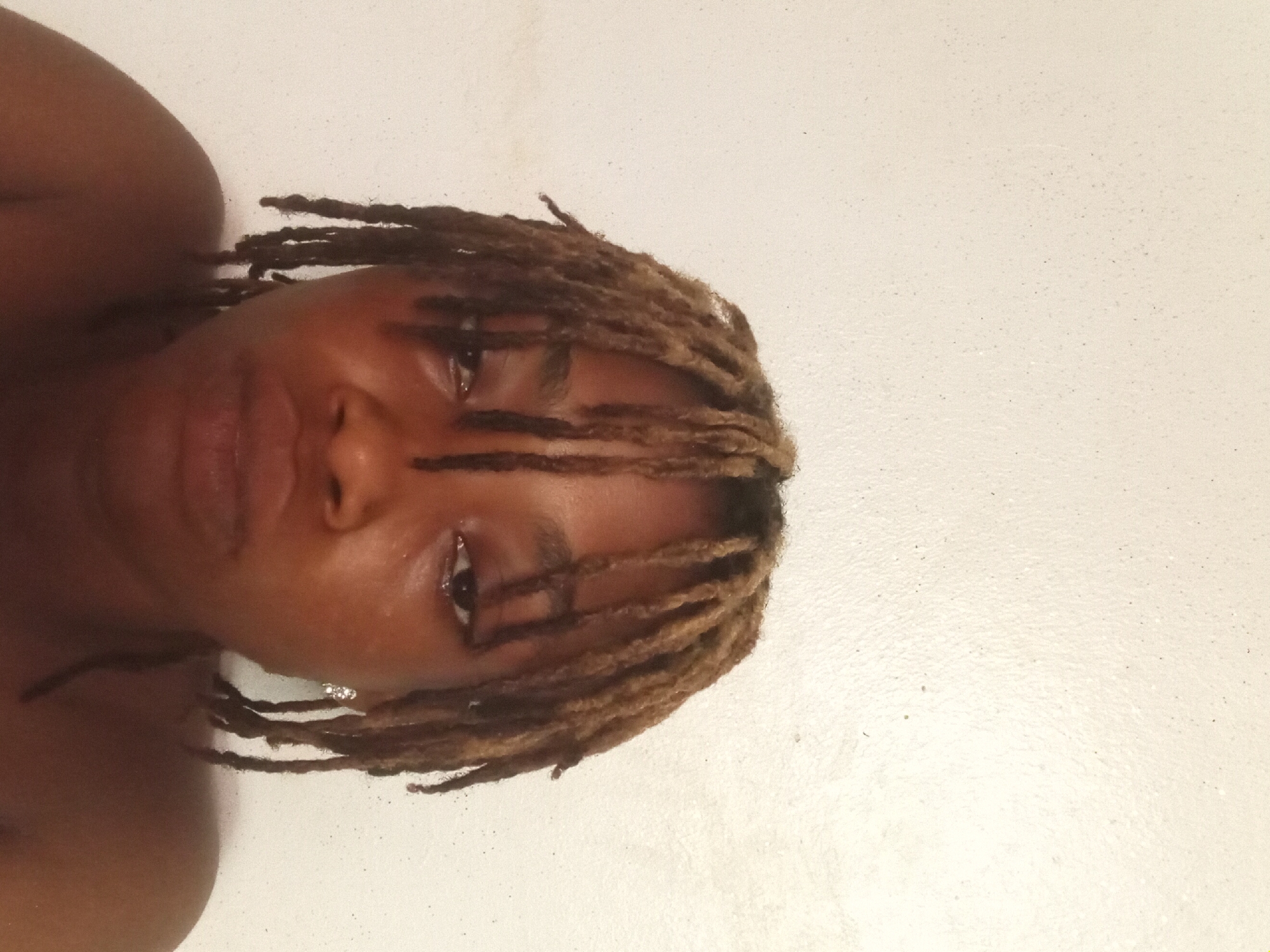 Person with dreadlocks poses for peace sign portrait photos