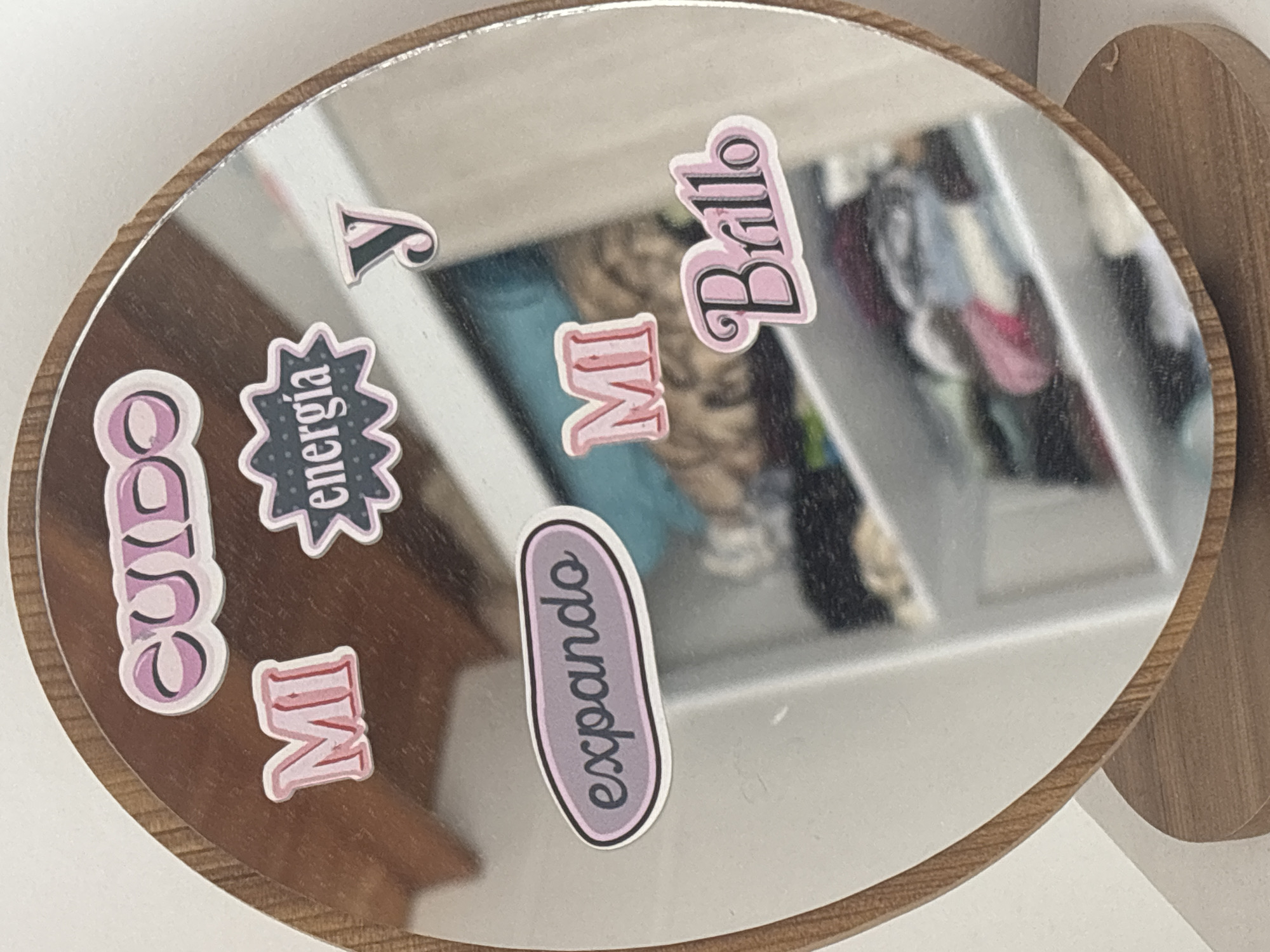 Motivational Spanish stickers adorn wooden-framed mirror in Medellín