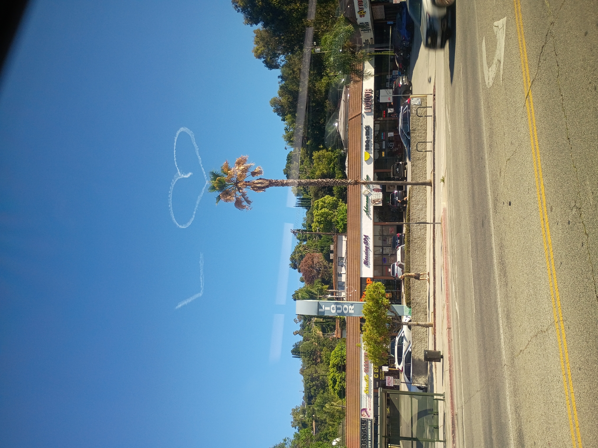 Skywriting contrails form a heart above Los Angeles streets