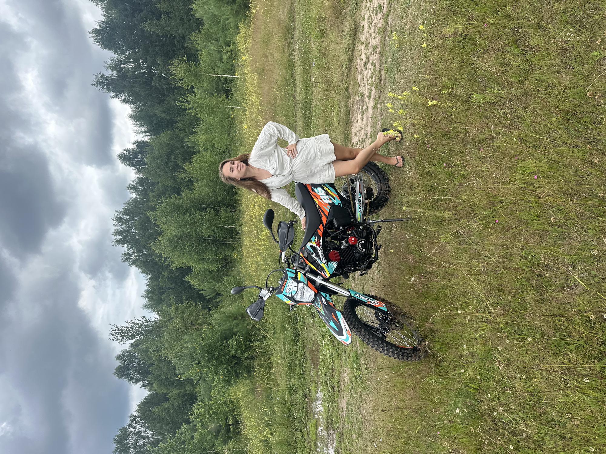 Posing with dirt bikes in a grassy Russian field
