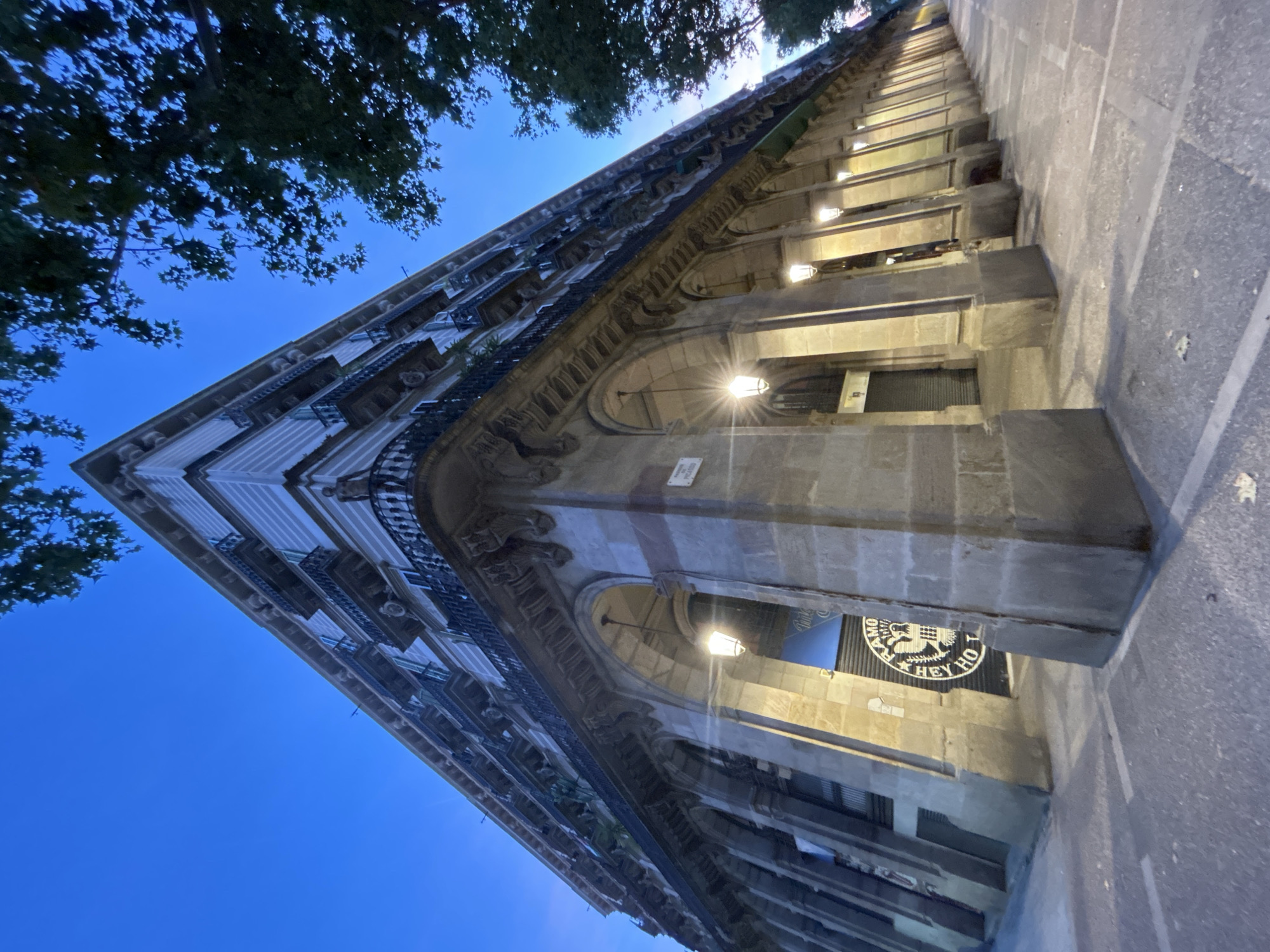 Gothic facades and arched colonnades in evening Barcelona