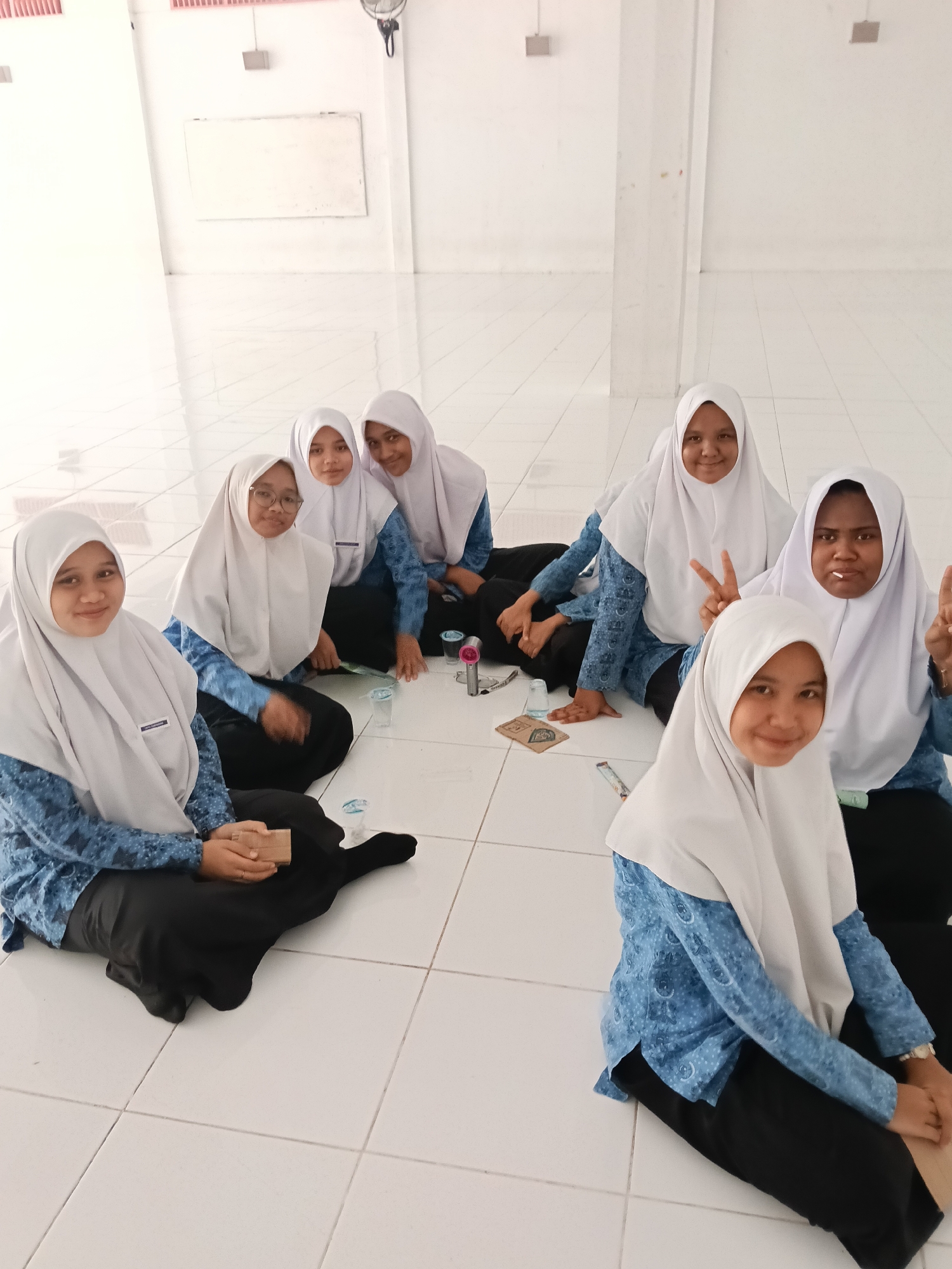 Seven women gather indoors at Lhokseumawe building early morning
