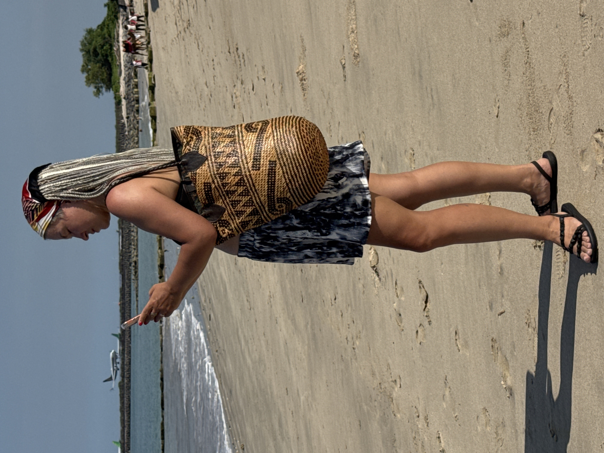 Tourist camels operate on Kuta Beach during morning hours