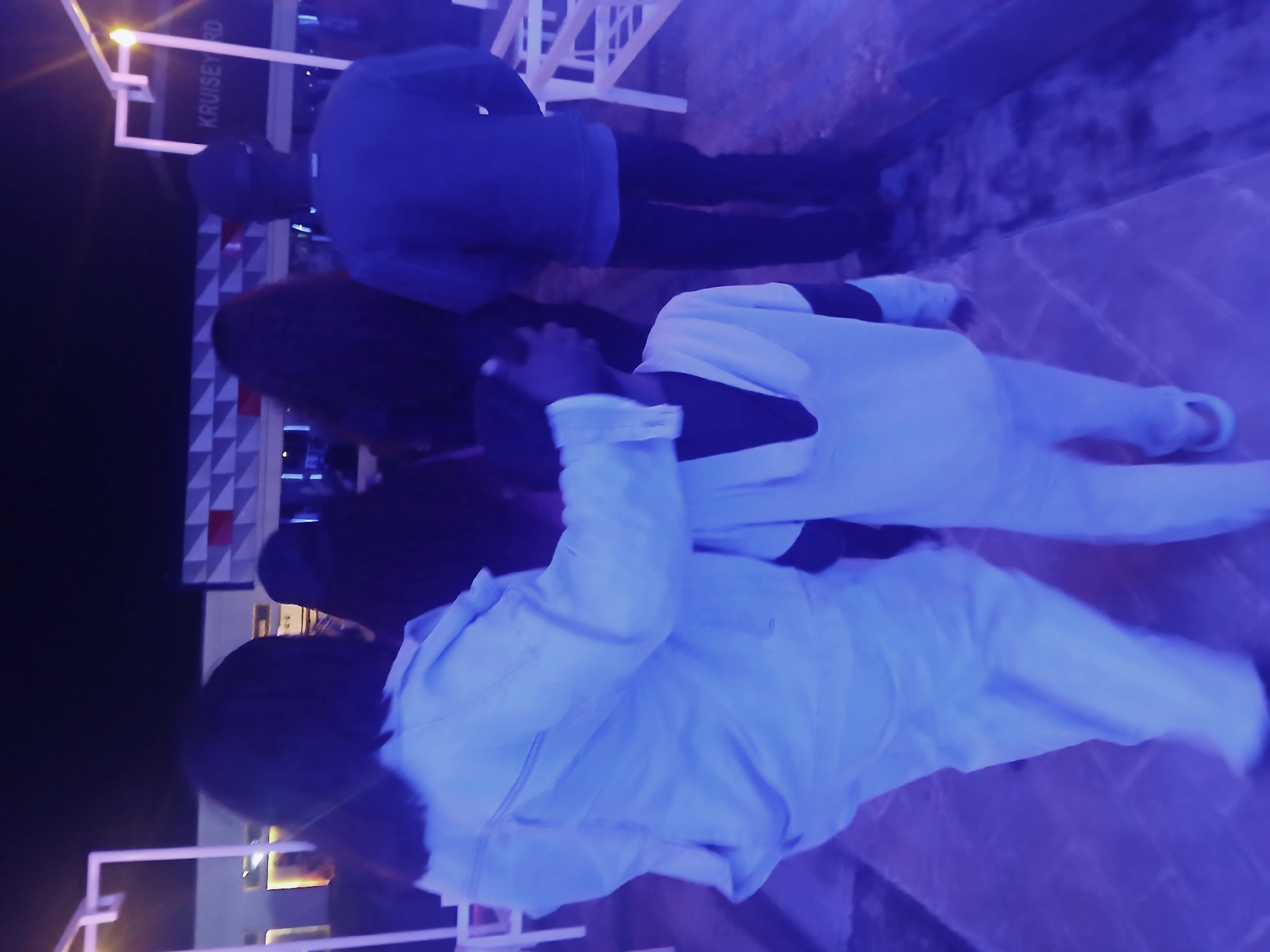 Evening pedestrian activity near illuminated building in Kitwe