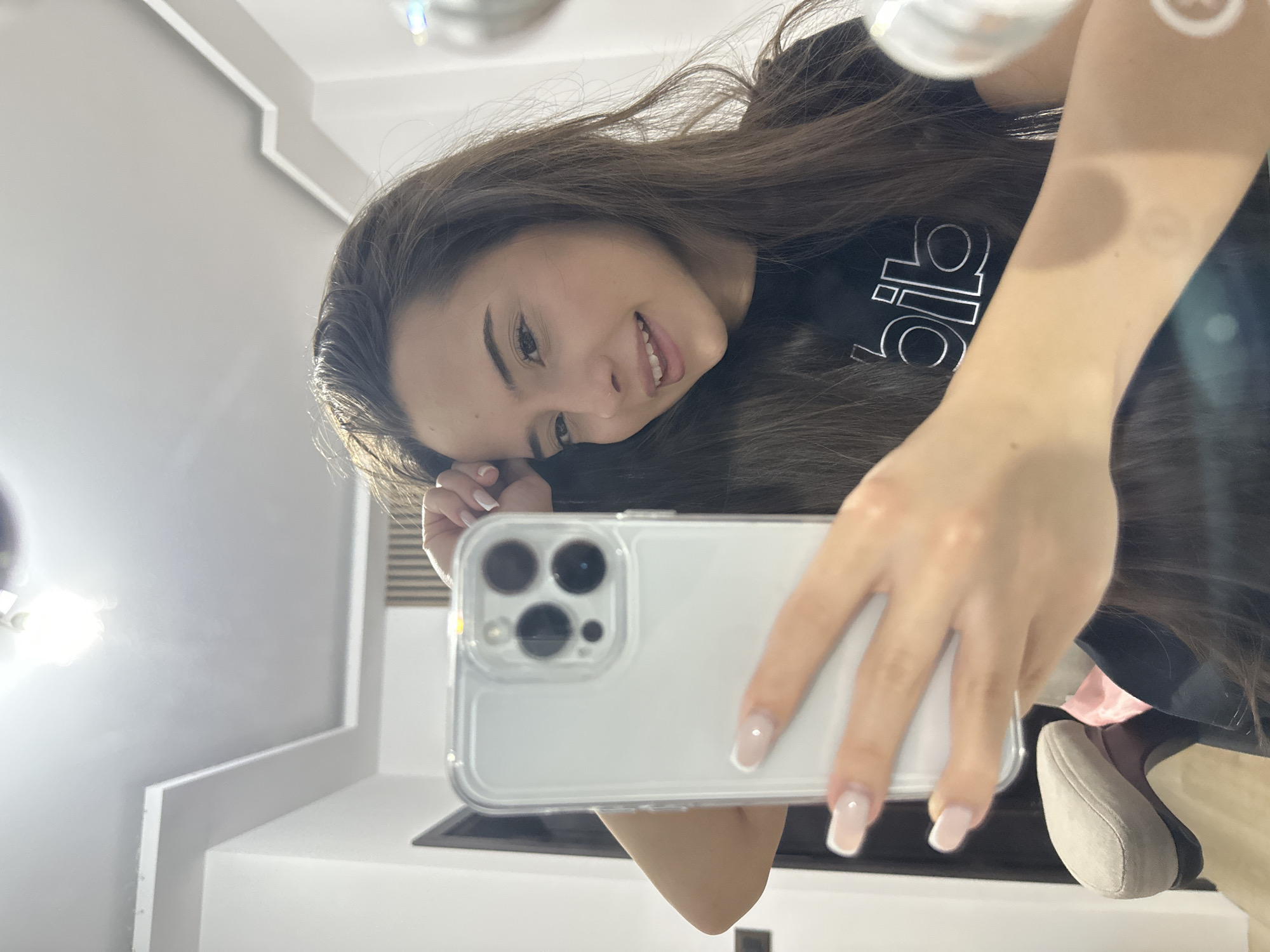 Woman Takes Multiple Mirror Selfies in Black Adidas Shirt