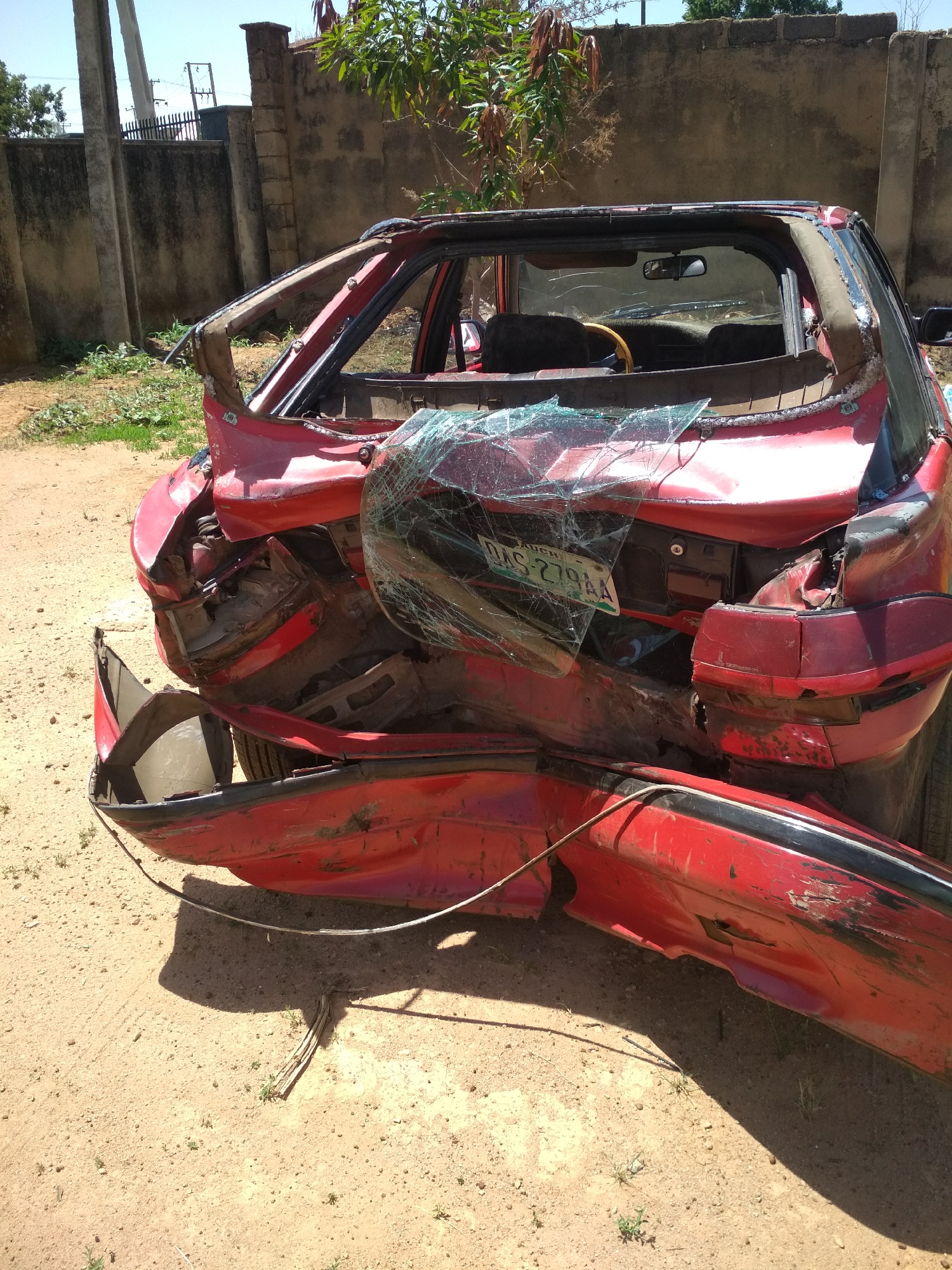 Damaged car, rickshaw with PTA-916 plate documented on dirt lot