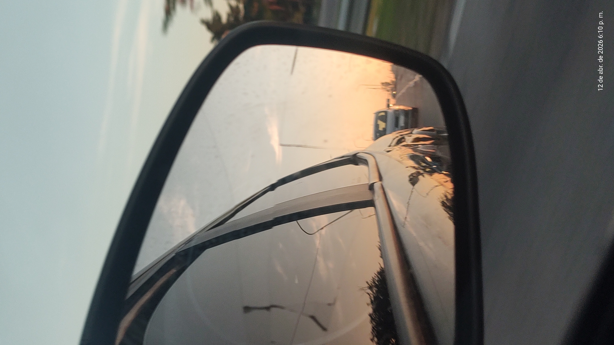 Driver captures sunset reflection in side mirror, Villa Domínico