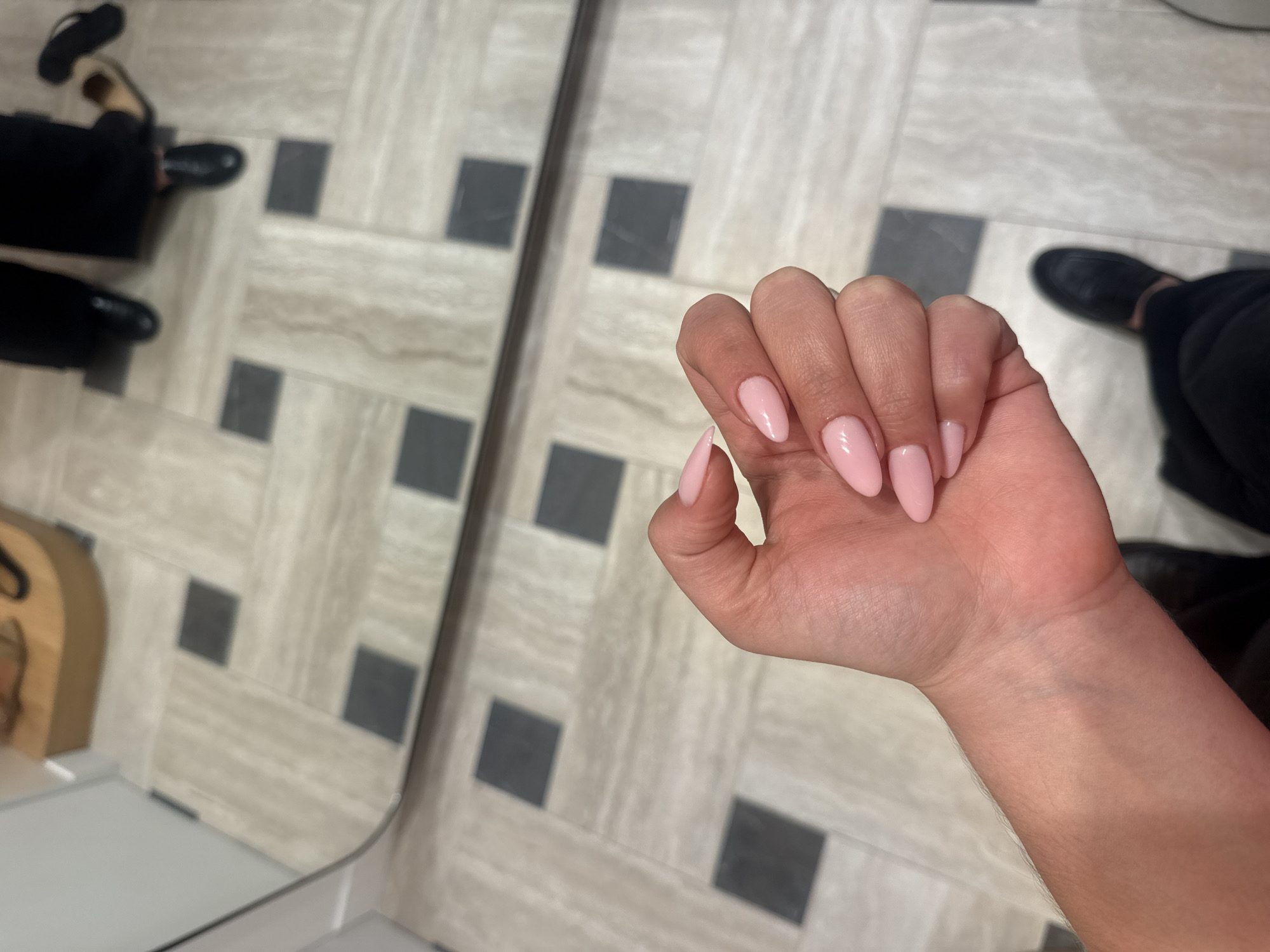 Manicured hand photographed against mirror in Paris