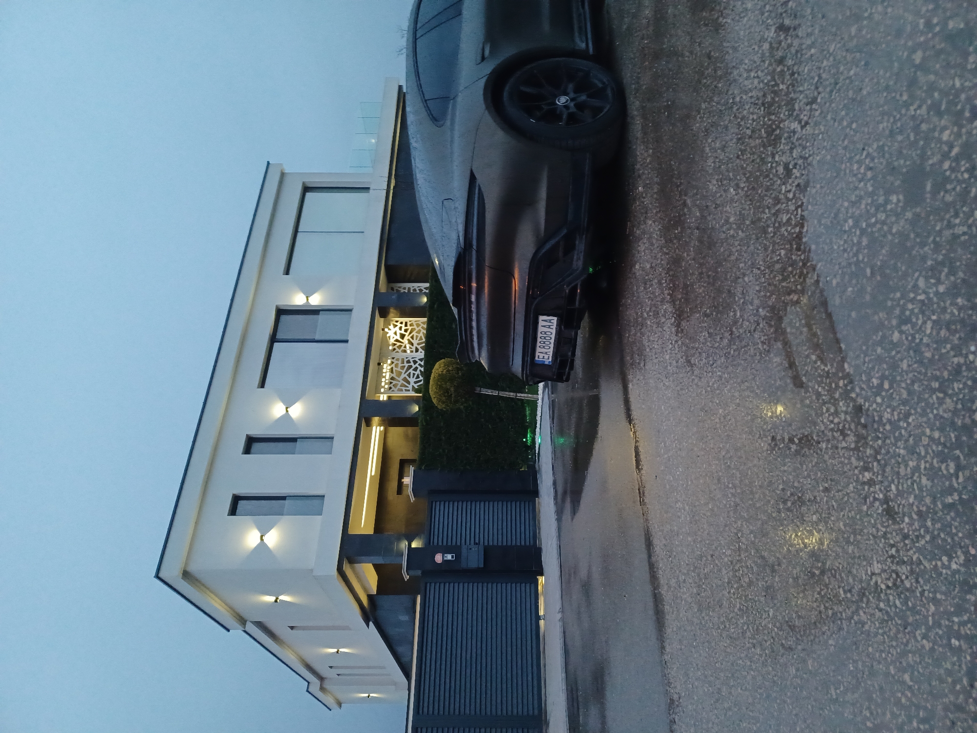Car parked outside modern house on wet Topoli street