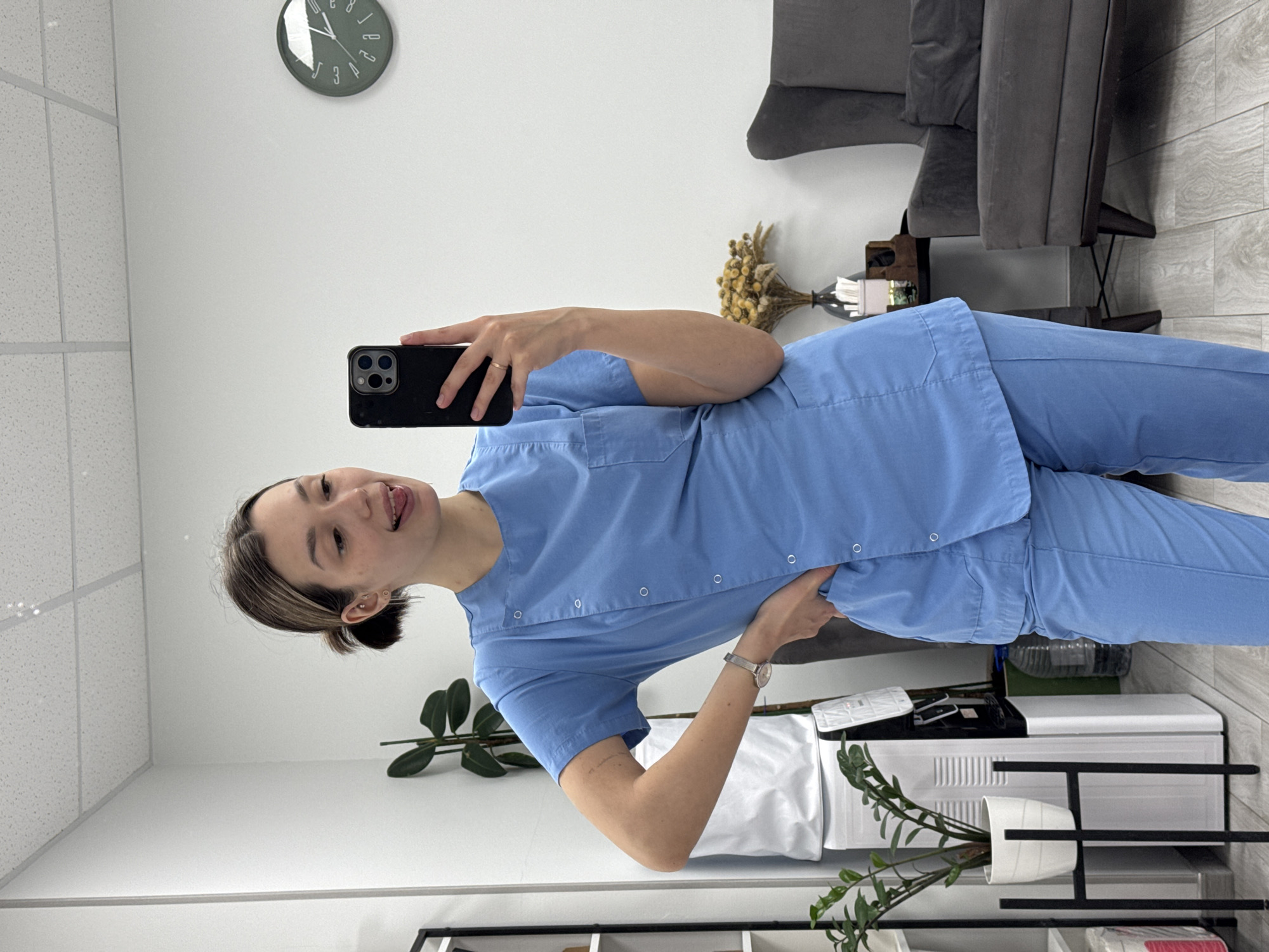 Woman takes mirror selfies in office waiting room