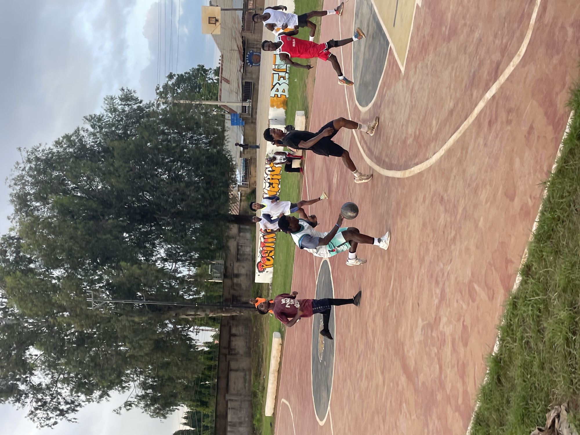 Pickup basketball on a red outdoor court in Gura Top, Nigeria
