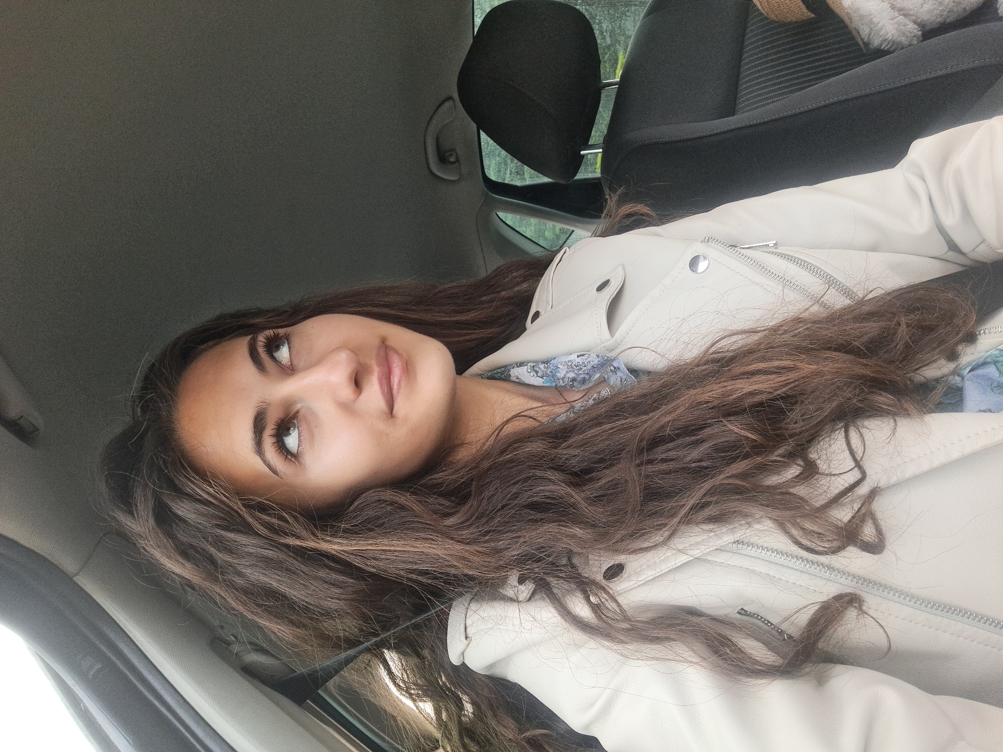 Woman gives thumbs-up in car with teddy bear, Lozen