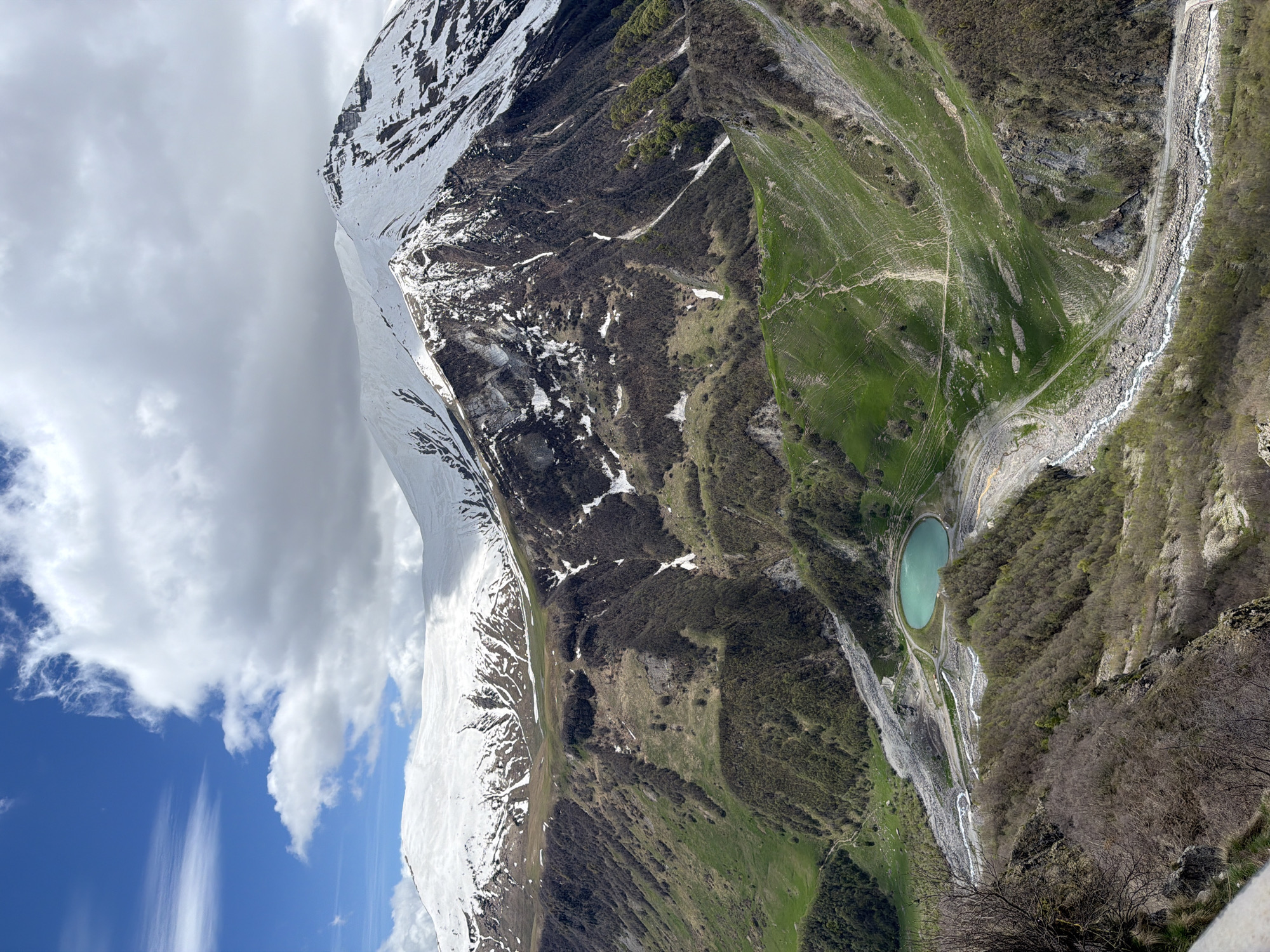 Tourist documents friendship monument and snowy peaks in Gudauri
