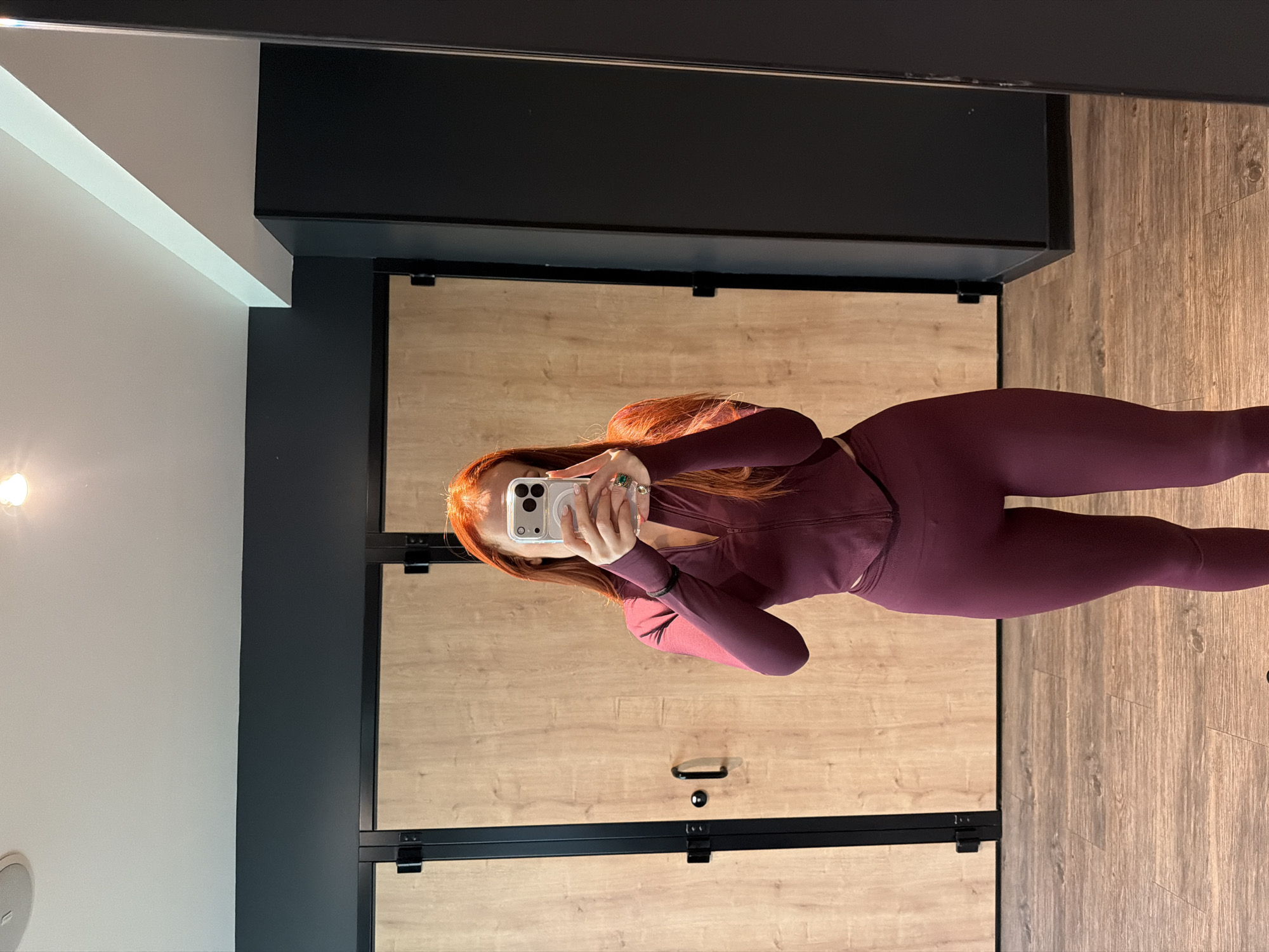 Woman takes gym selfie in burgundy activewear in Paris