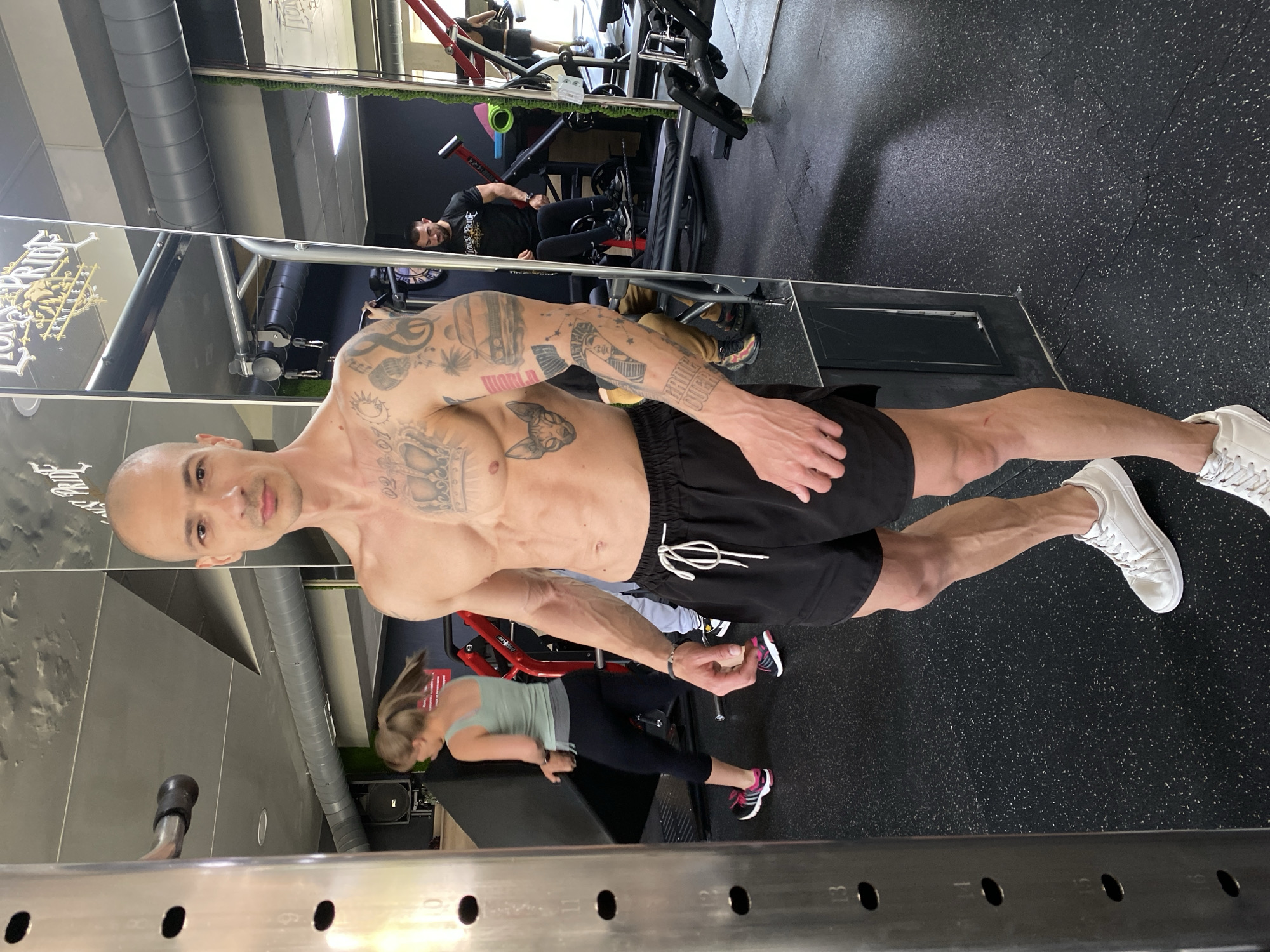 Tattooed fitness enthusiast poses at Pleven gym