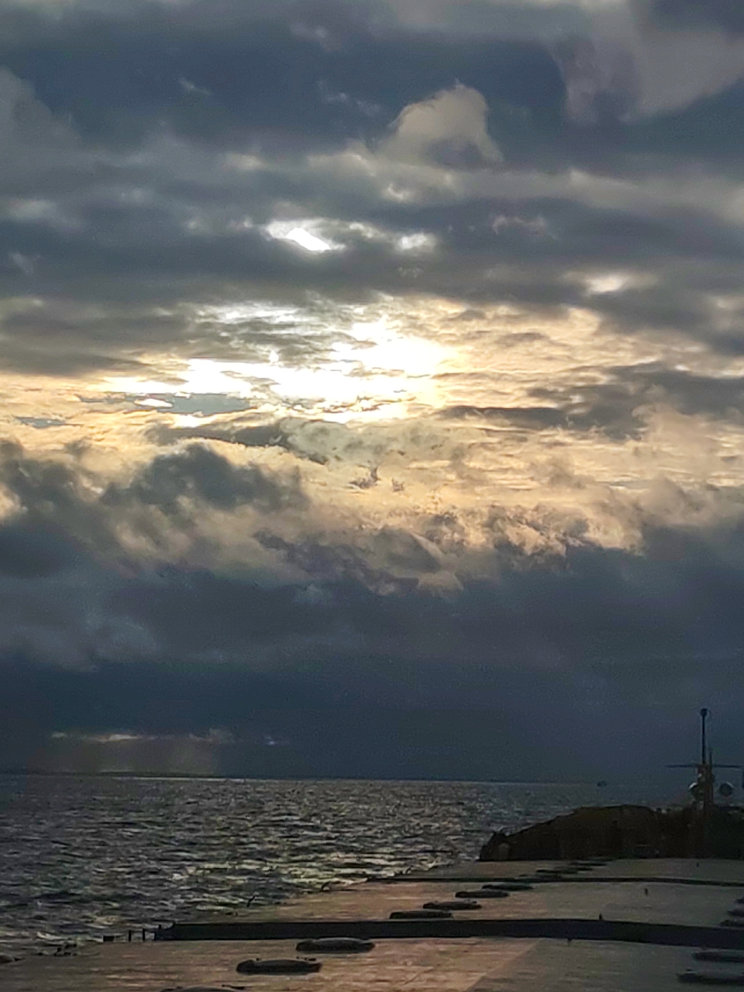 Cloudy afternoon captured at concrete pier with choppy waters