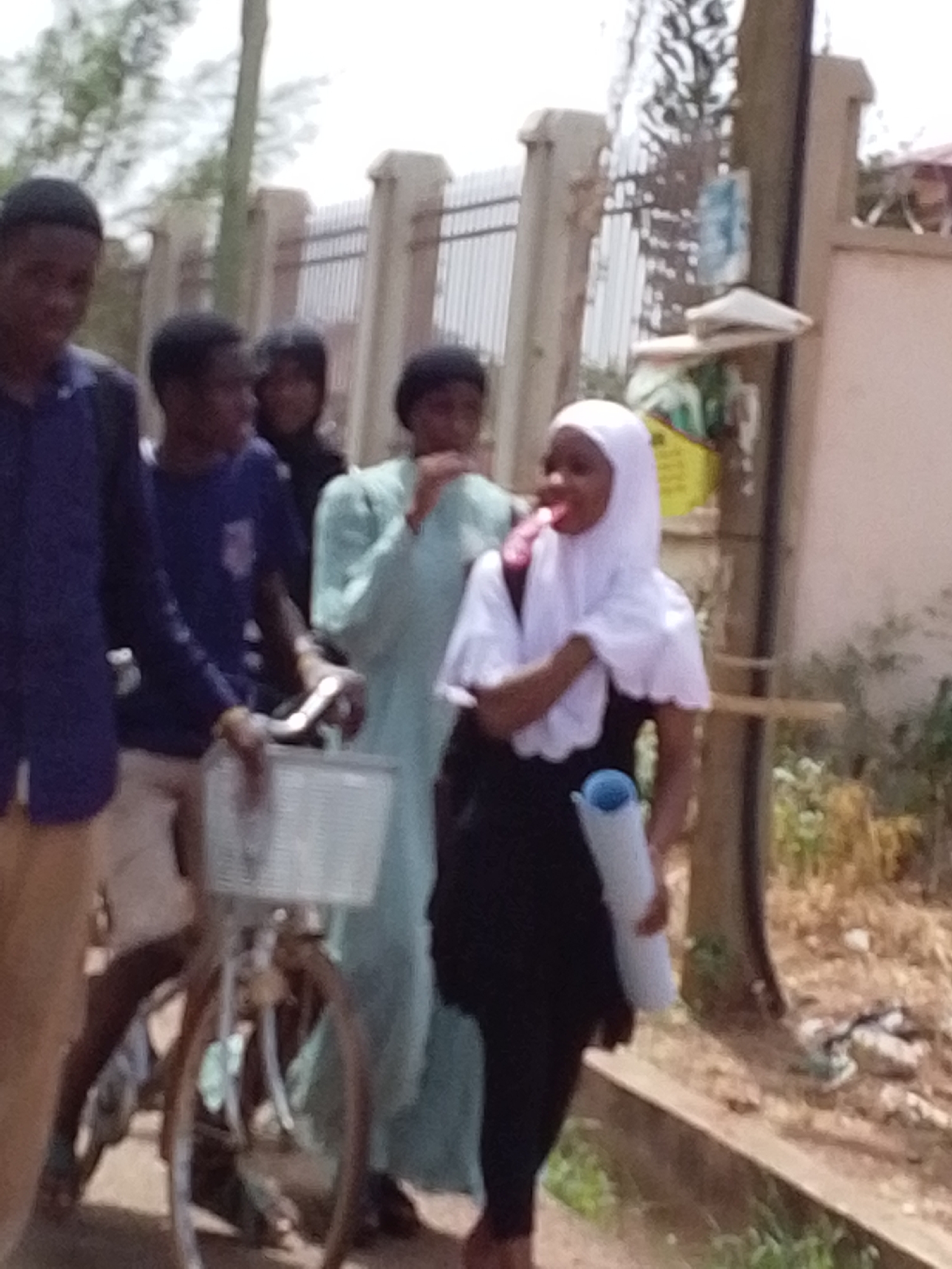 Group gathers on street with cyclist in Tamale