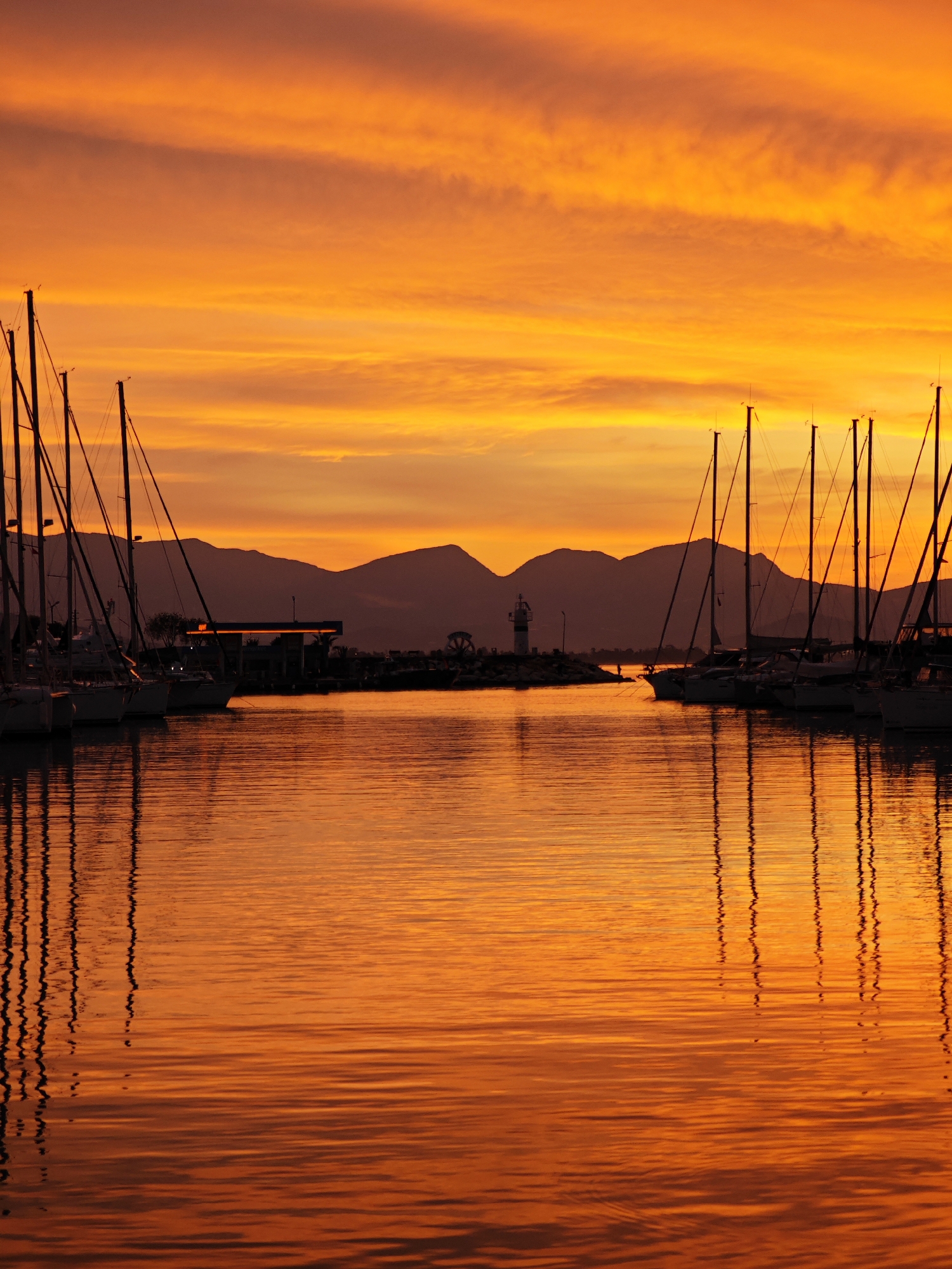 Sunset documented at Finike marina with sailboats and lighthouse