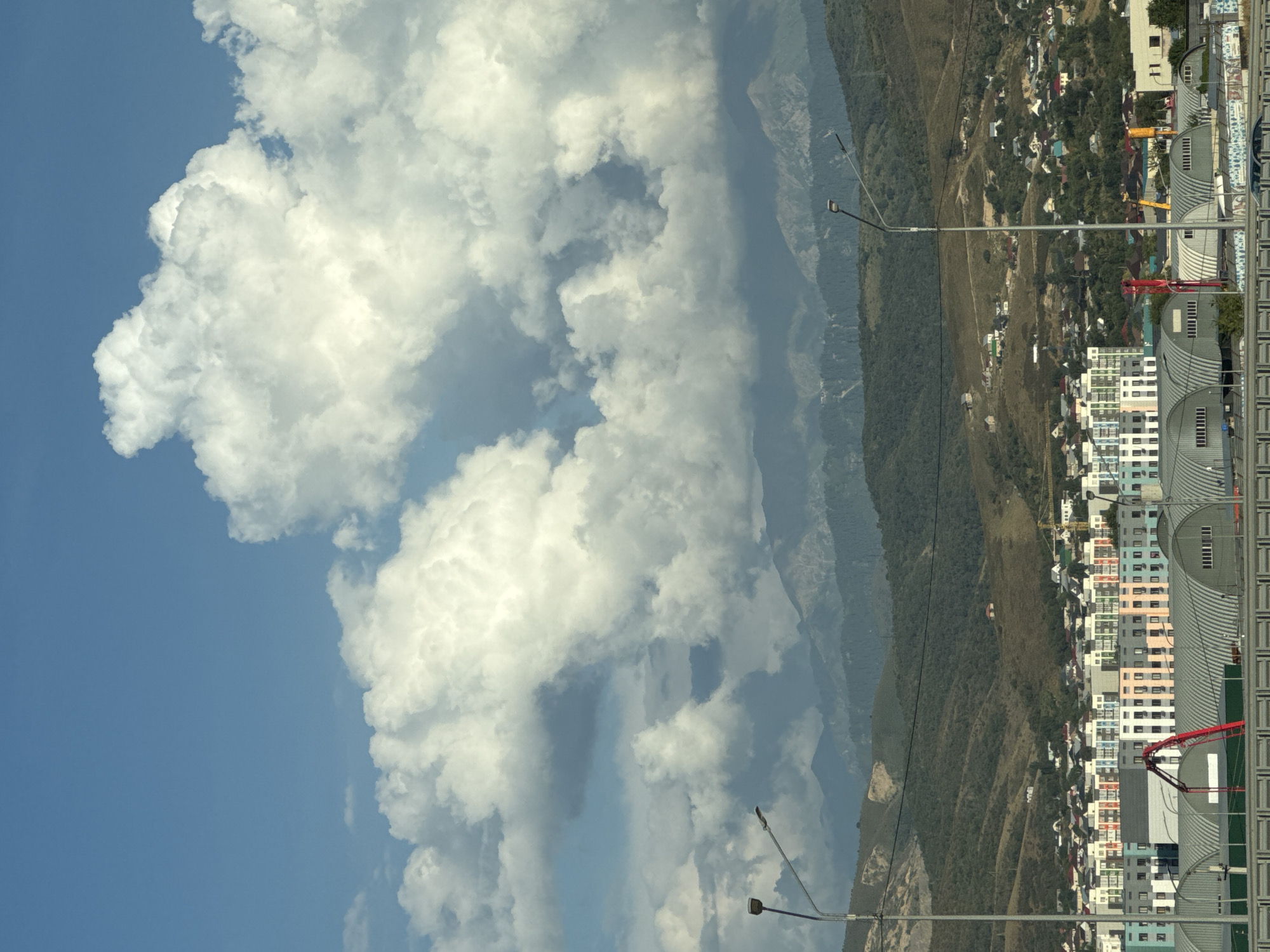 Almaty residential sprawl backed by mountains on a cloudy day