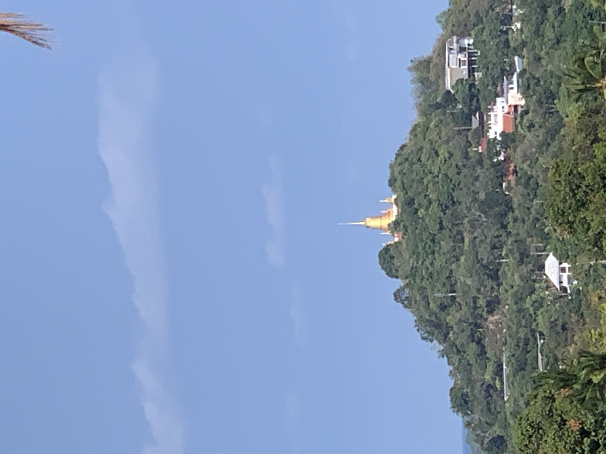 Golden temple overlooks coastal landscape in บ้านบางรักษ์, Thailand