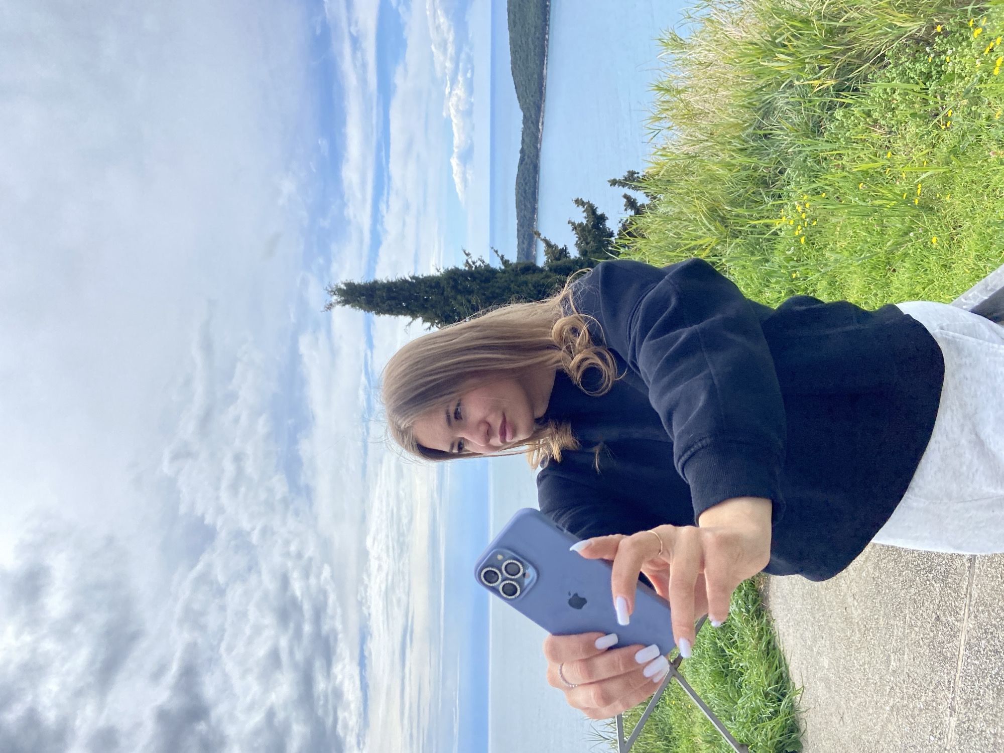 Woman photographs scenic coastal views during Montenegro overlook visit