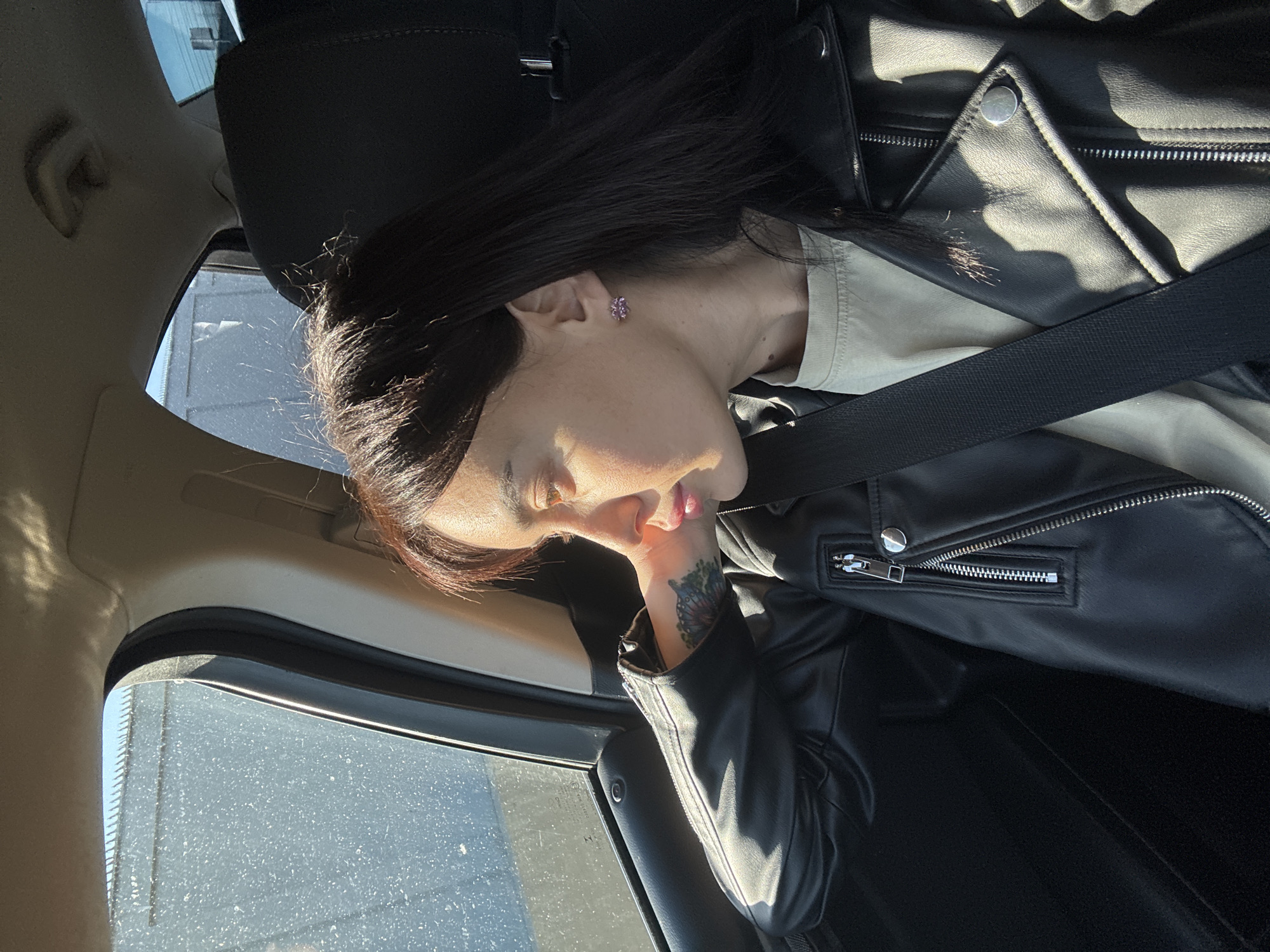 Woman rests in car near Tbilisi monument during highway travel