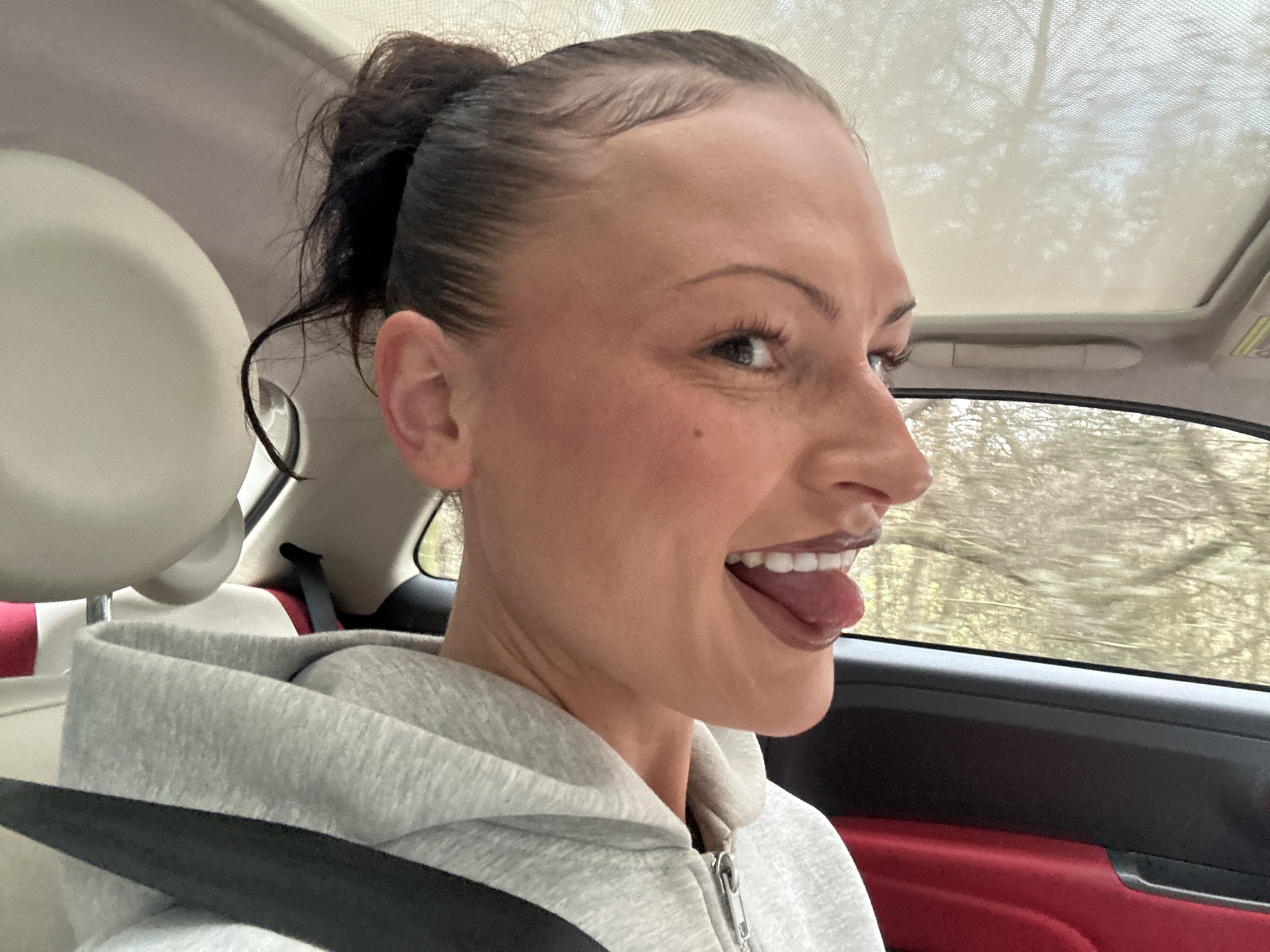 Woman makes playful expression while in vehicle in Wealden