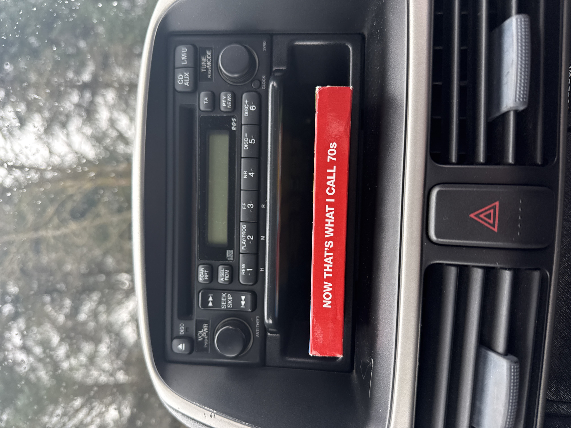 Person rests in car with feet up, radio visible